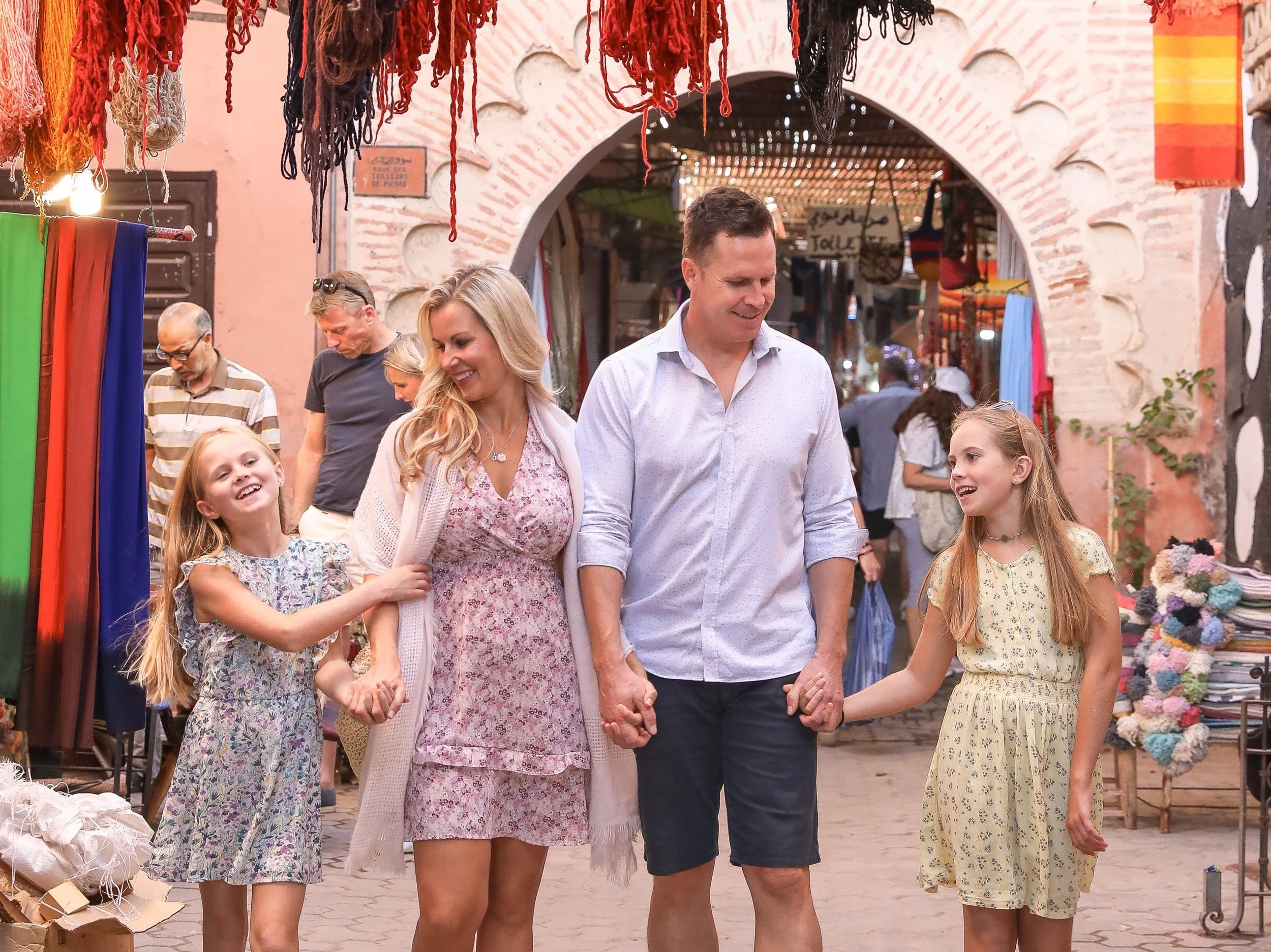Family shopping for textiles in a colorful covered market
