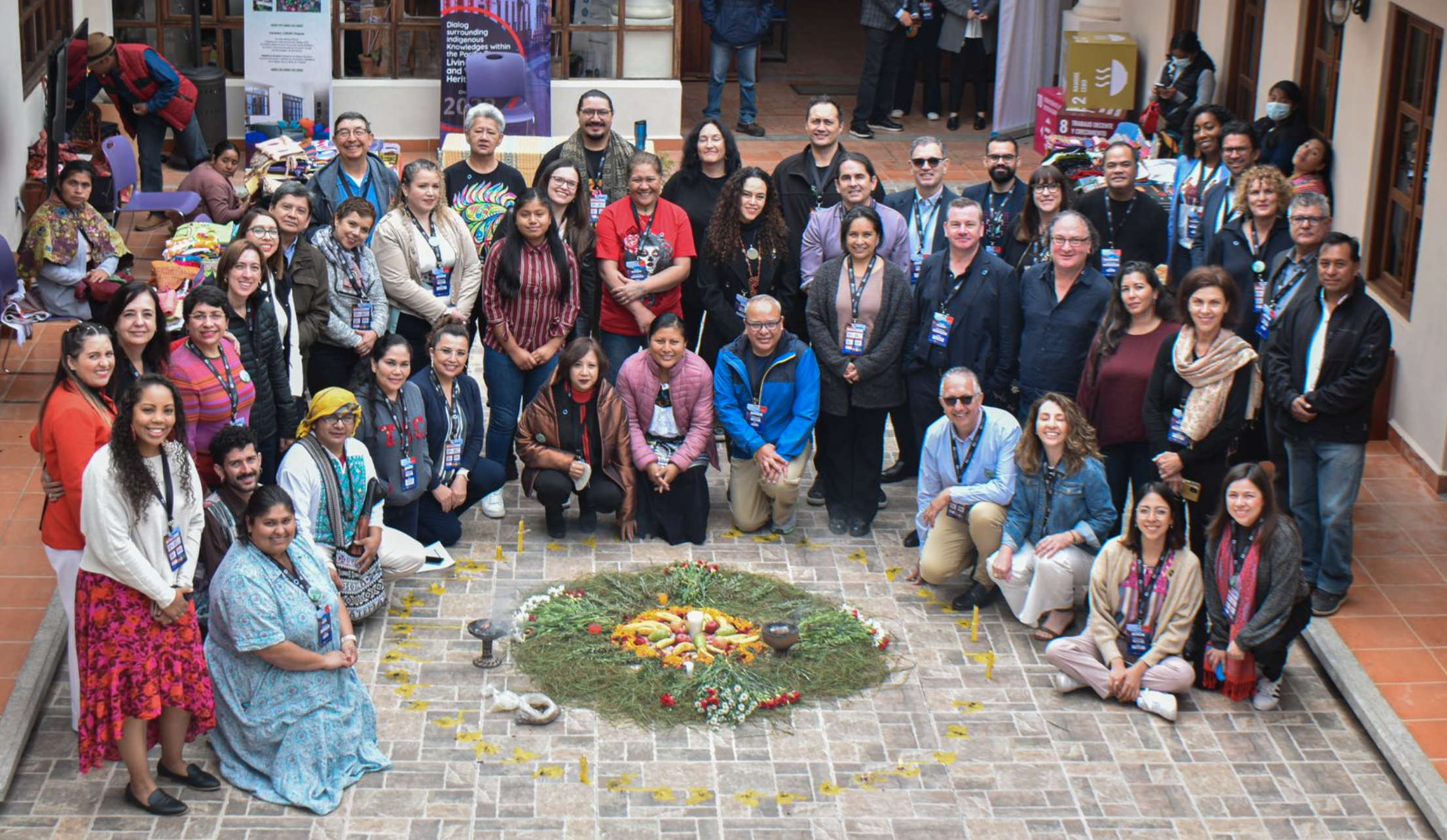 A large group of people gathered around a collection of fruit and flowers at the first meeting of the Association of Pacific Rim Universities Indigenous Knowledges Network in Chiapas, Mexico
