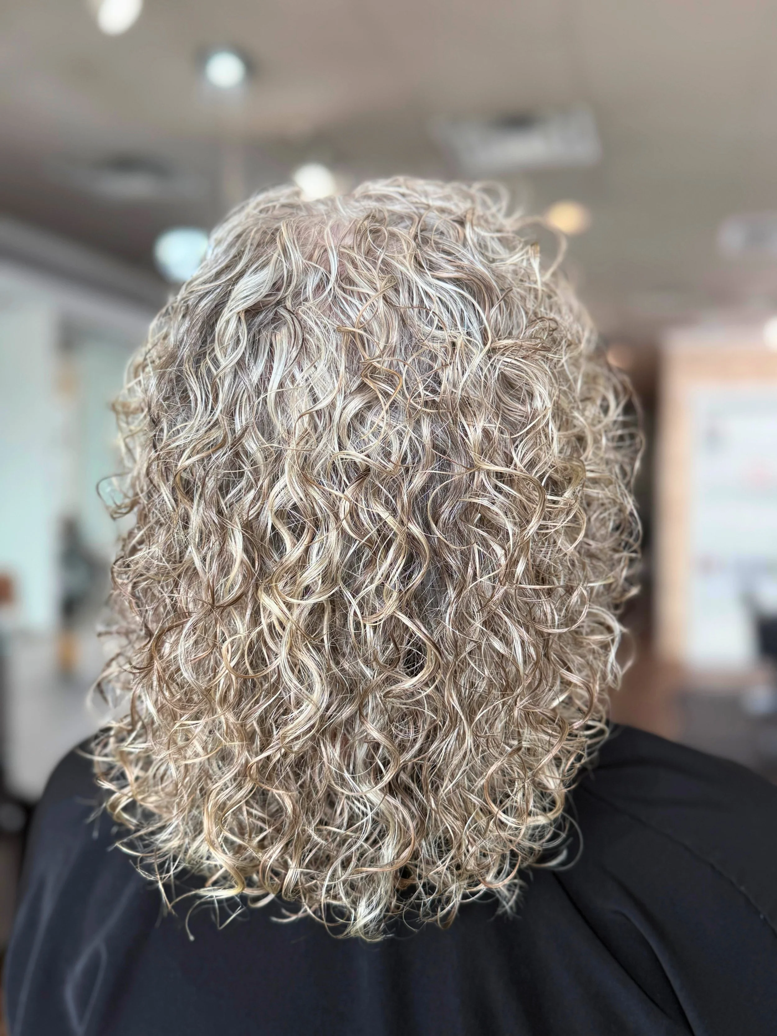 Defined, voluminous curls created with a professional perm treatment for long-lasting waves at Pani Style Hair Salon, Katy, TX.