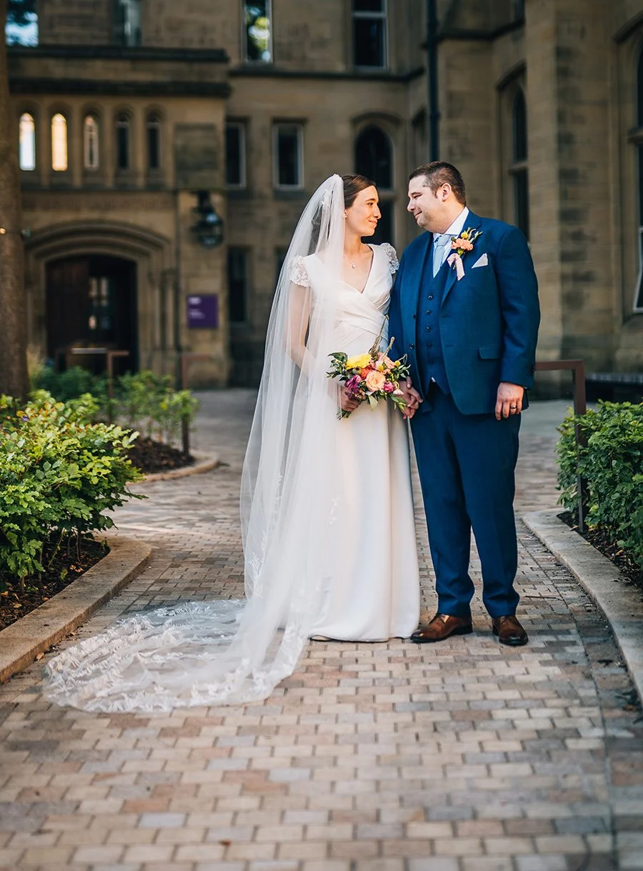 Couple loving look with colourful wedding bouquet and buttonhole