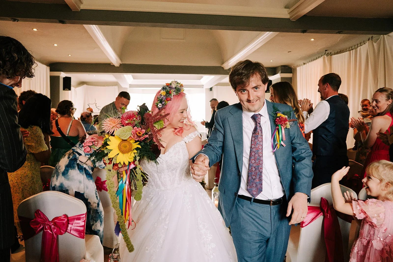 Bride and groom celebrating getting married at colourful flower wedding created by MillieBuds Colour Loving Wedding Florist in Stockport at Bowdon Rooms