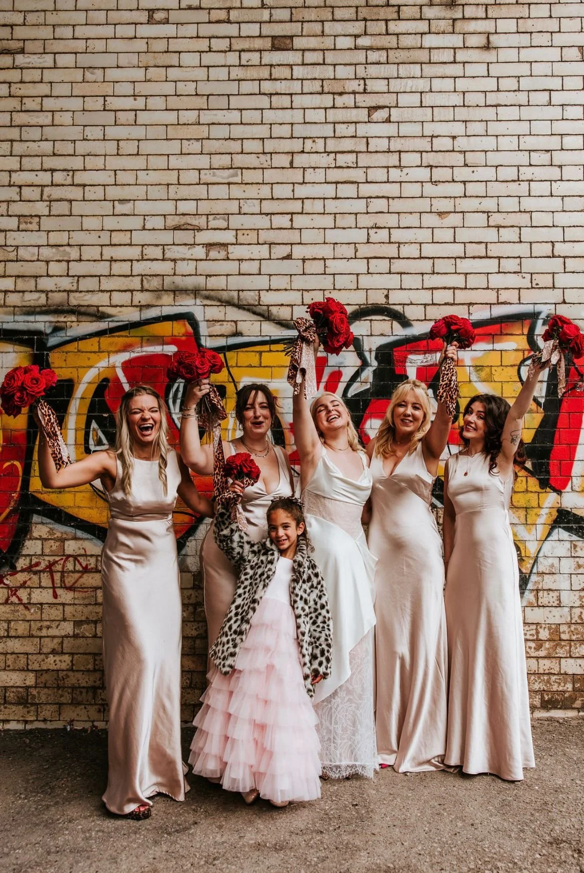 Fun bridal party in front of graffiti wall