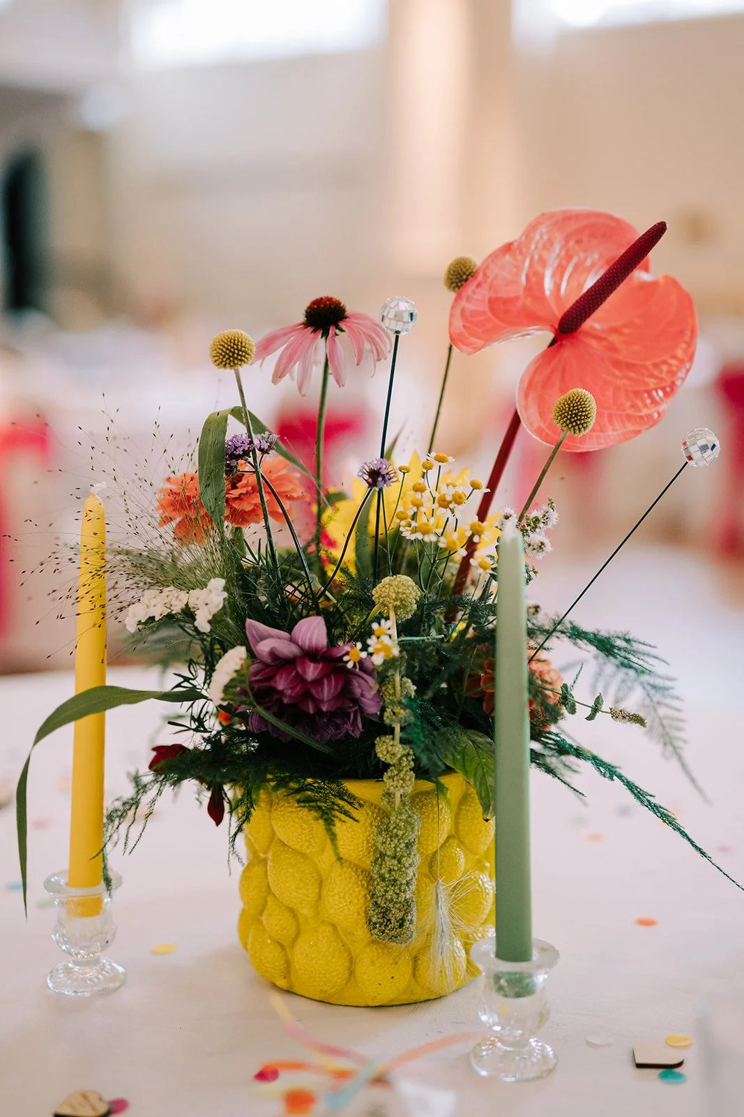 Colourful flower centrepiece in yellow vase created by MillieBuds Colour Loving Wedding Florist in Stockport at Bowdon Rooms