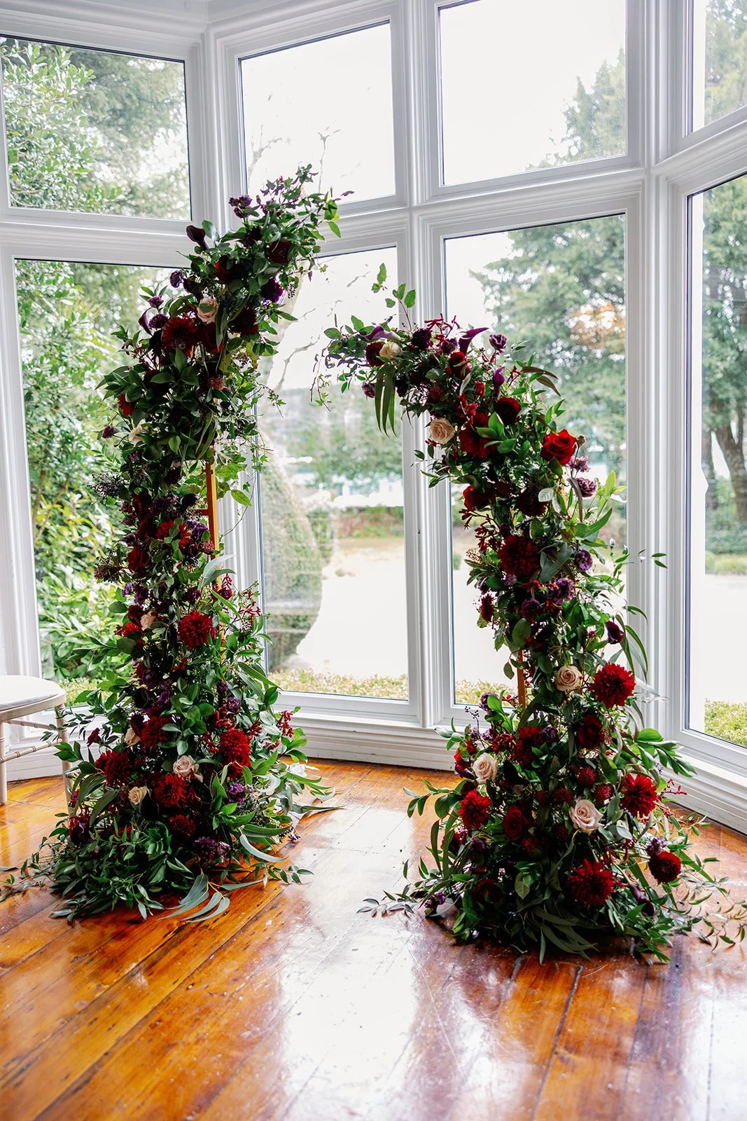 Moody red and purple wild split arch created by MillieBuds Wedding Florist, Stockport