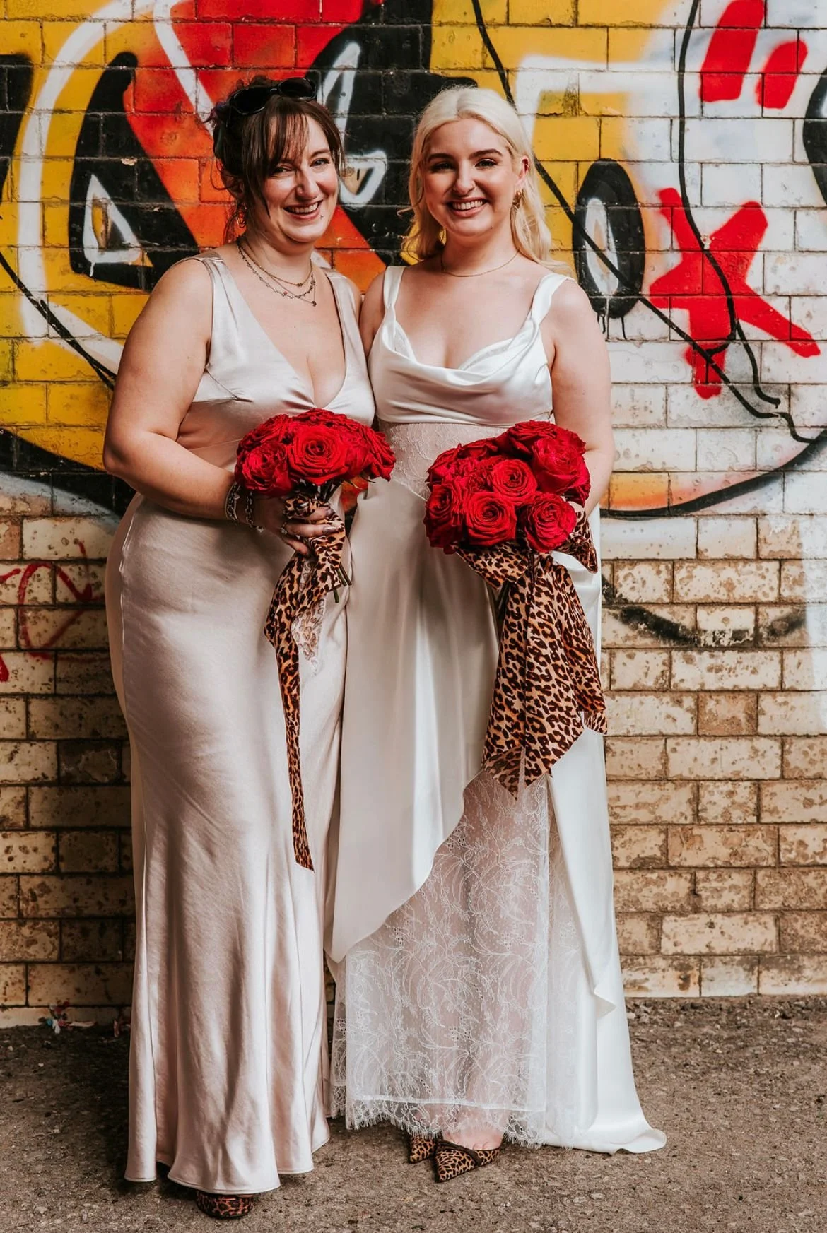 Bride and bridesmaid with red and pink cartoon bouquet