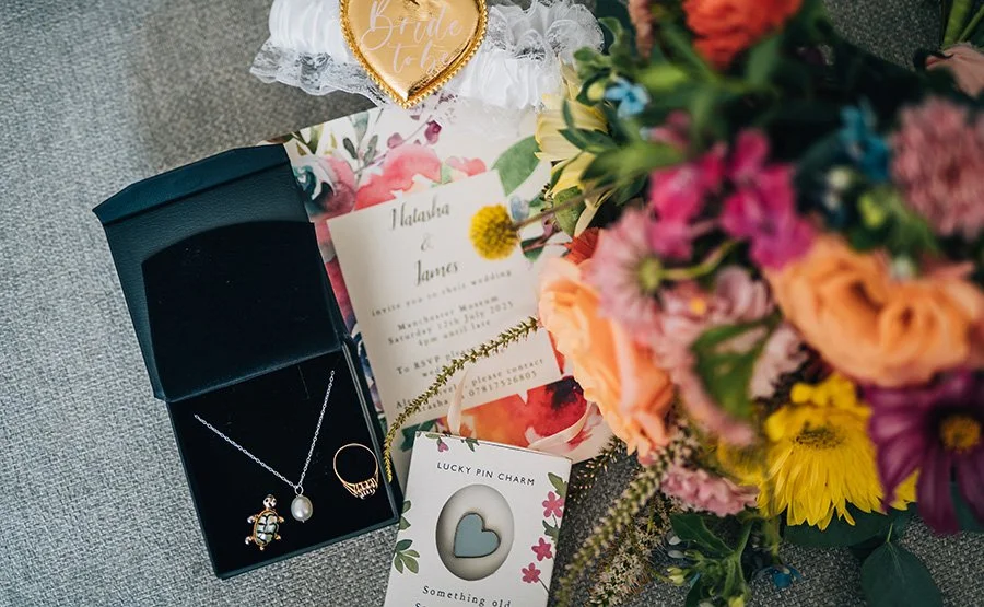 Flat lay of rings and bright colourful wedding bouquet