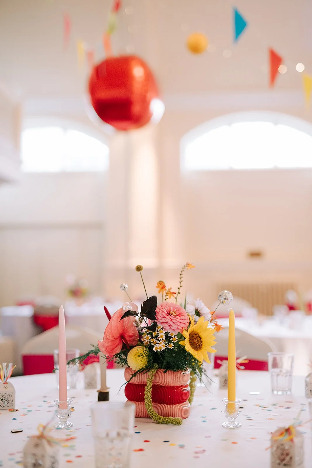 Wedding colourful flower table centrepiece in pink and red heart vase created by MillieBuds Colour Loving Wedding Florist in Stockport at Bowdon Rooms