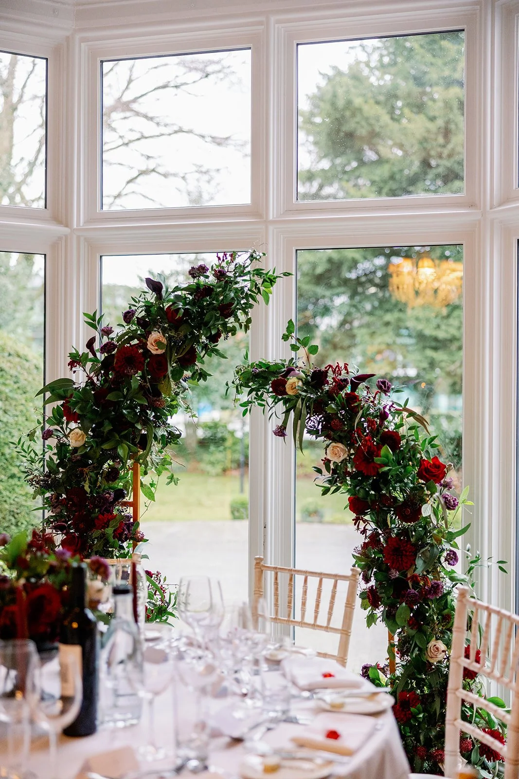 Wedding split arch moody red and purple wedding flowers