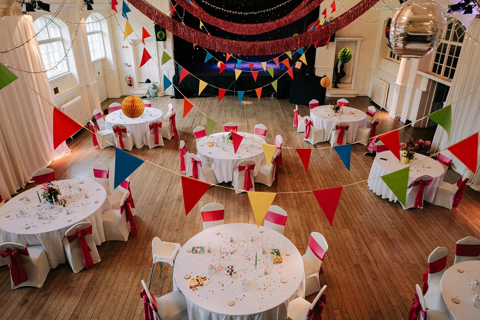 Fun colourful wedding breakfast room with bunting created by MillieBuds Colour Loving Wedding Florist in Stockport at Bowdon Rooms