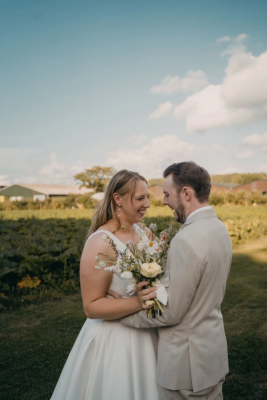 Couple embrace with white and pastel bouquet