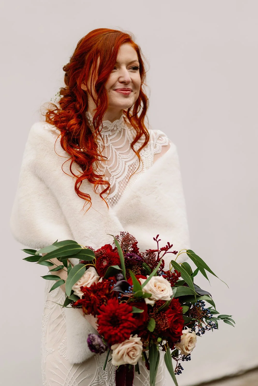 Bride with large moody red wedding bouquet