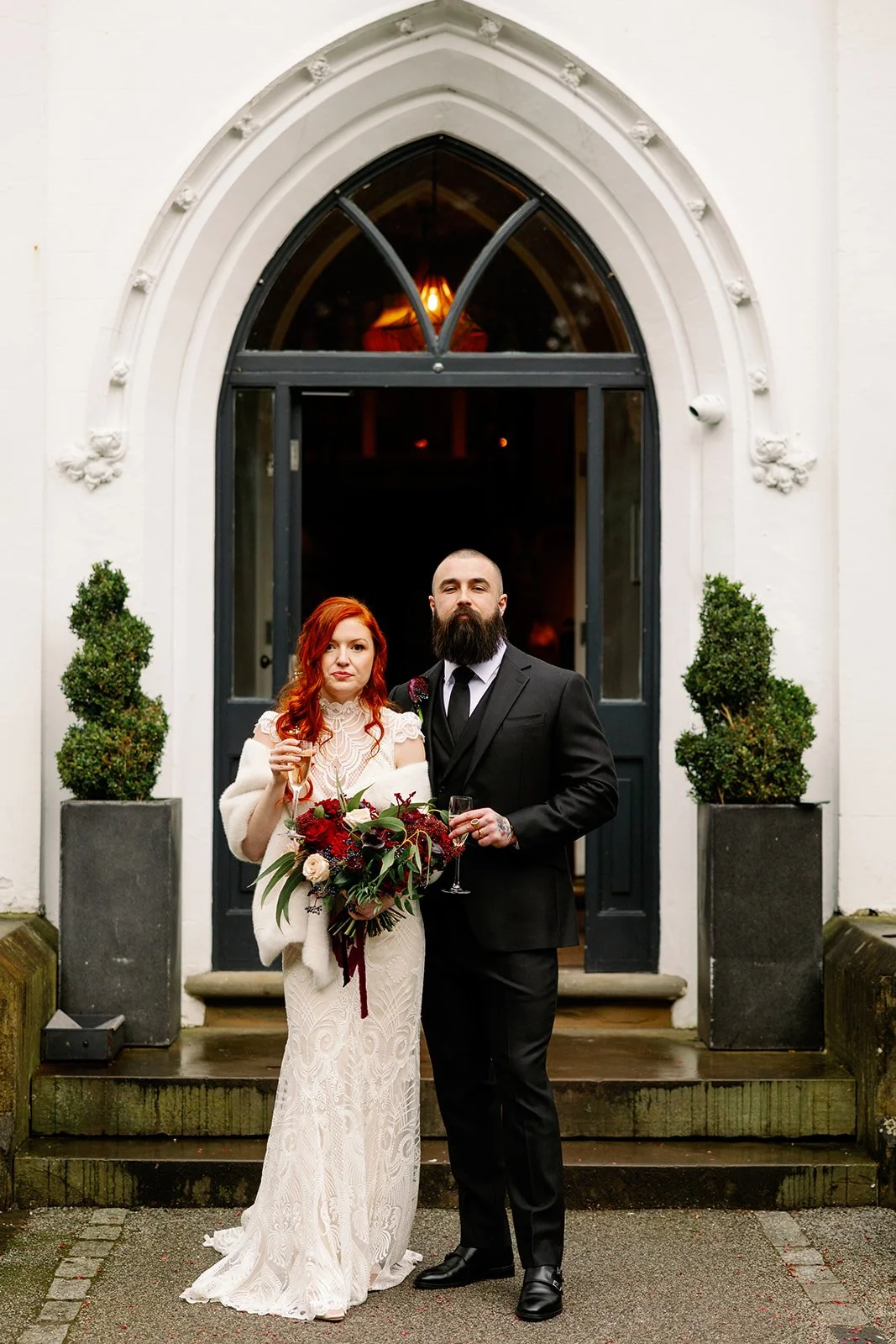 Couple outside with moody red bouquet