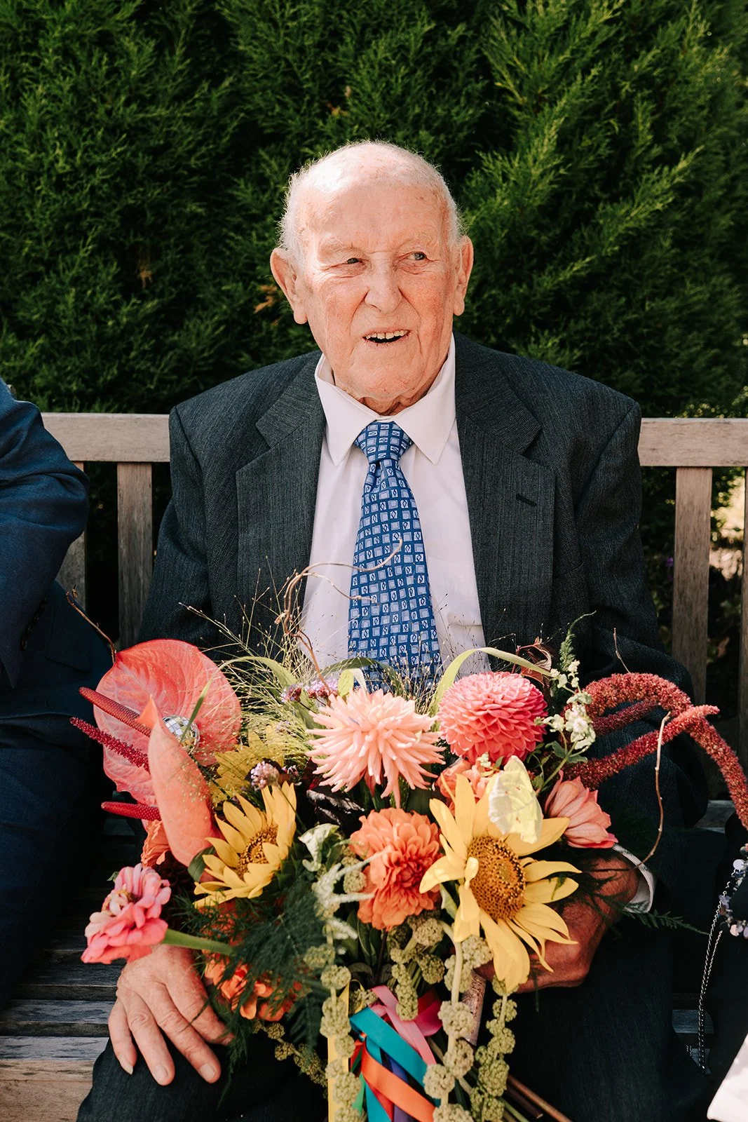 Grandfather holding colourful bridal bouquet