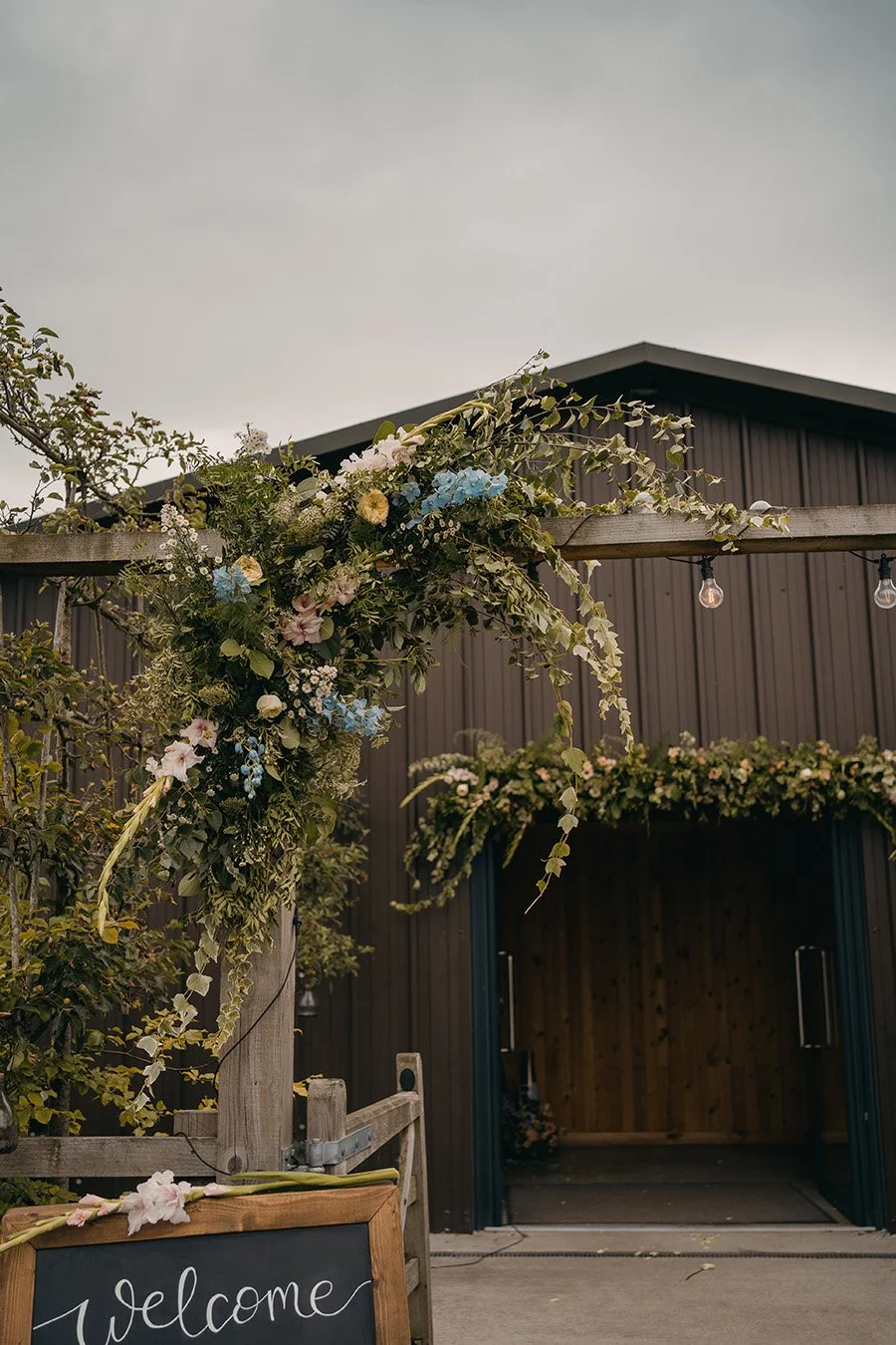 Outside corner wooden arch with wild foliage and pastel florals