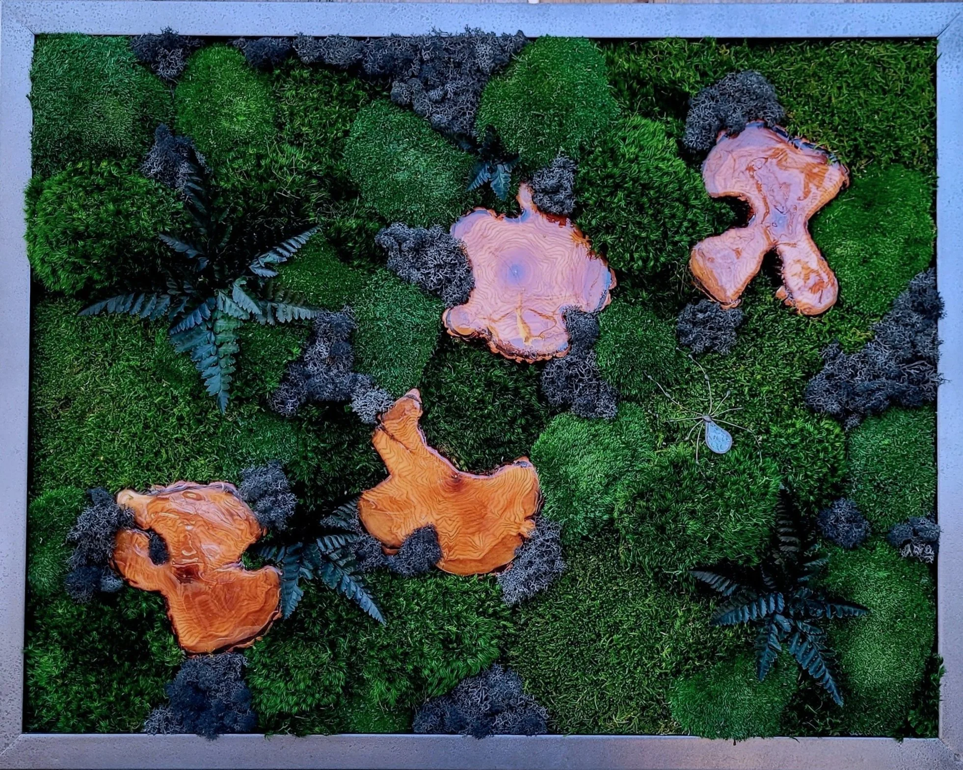 Framed wall art featuring green moss, fern leaves, and orange resin accents