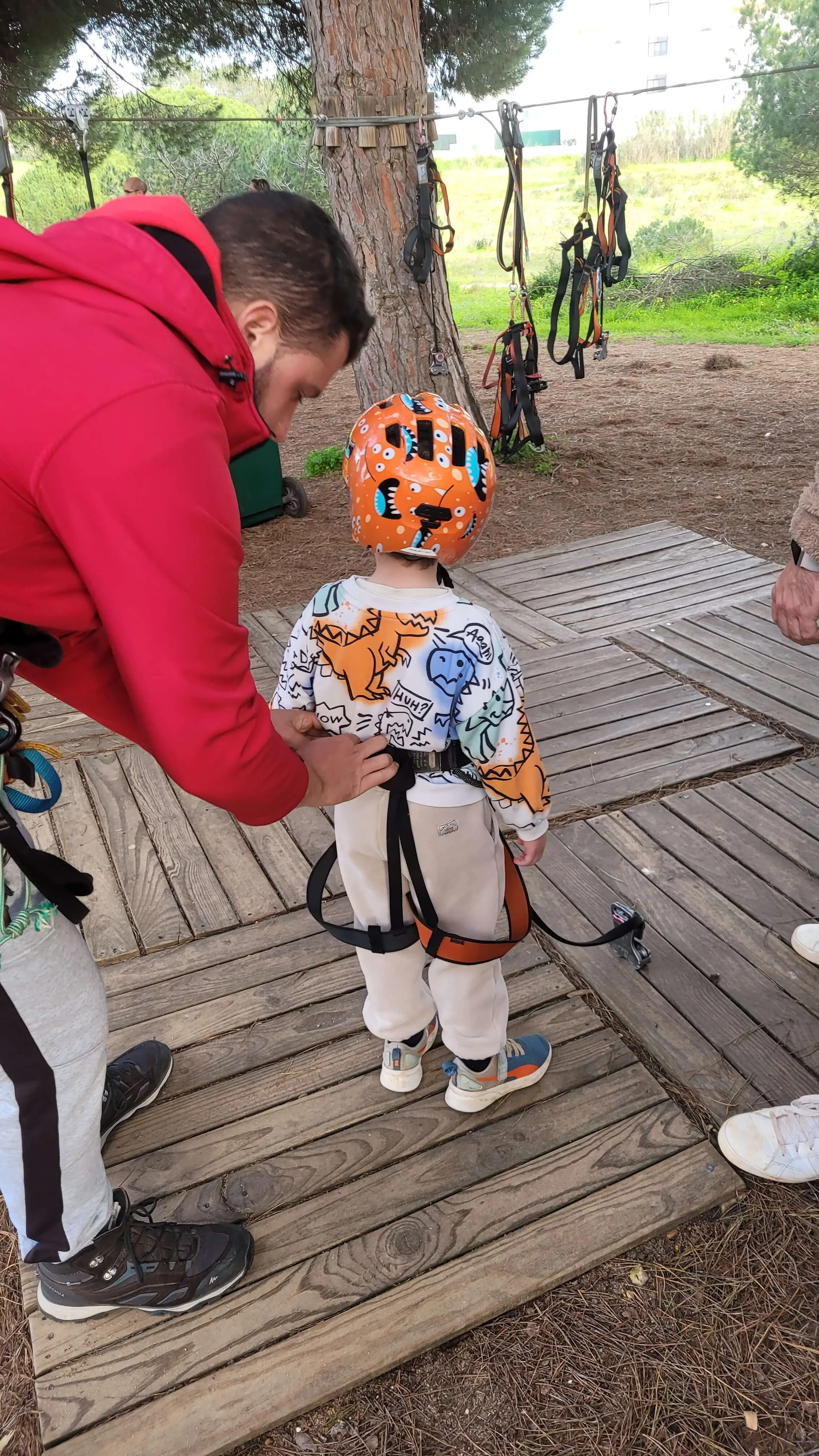 Staff helping a young child put on a climbing harness at Parque Aventura Lagos