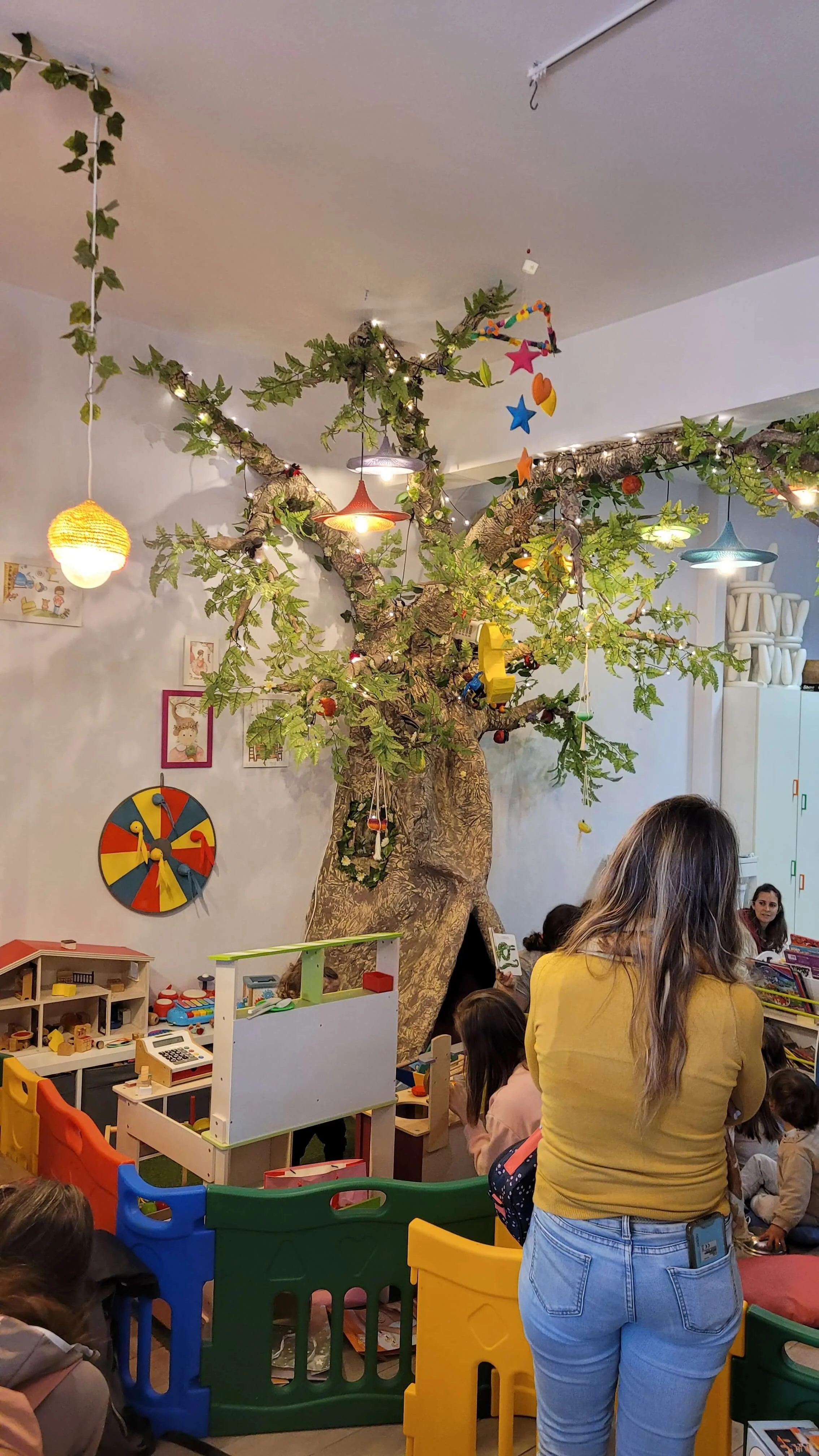 Magical tree with fairy lights toys and play area during a family event at Ate a Lua Lagos