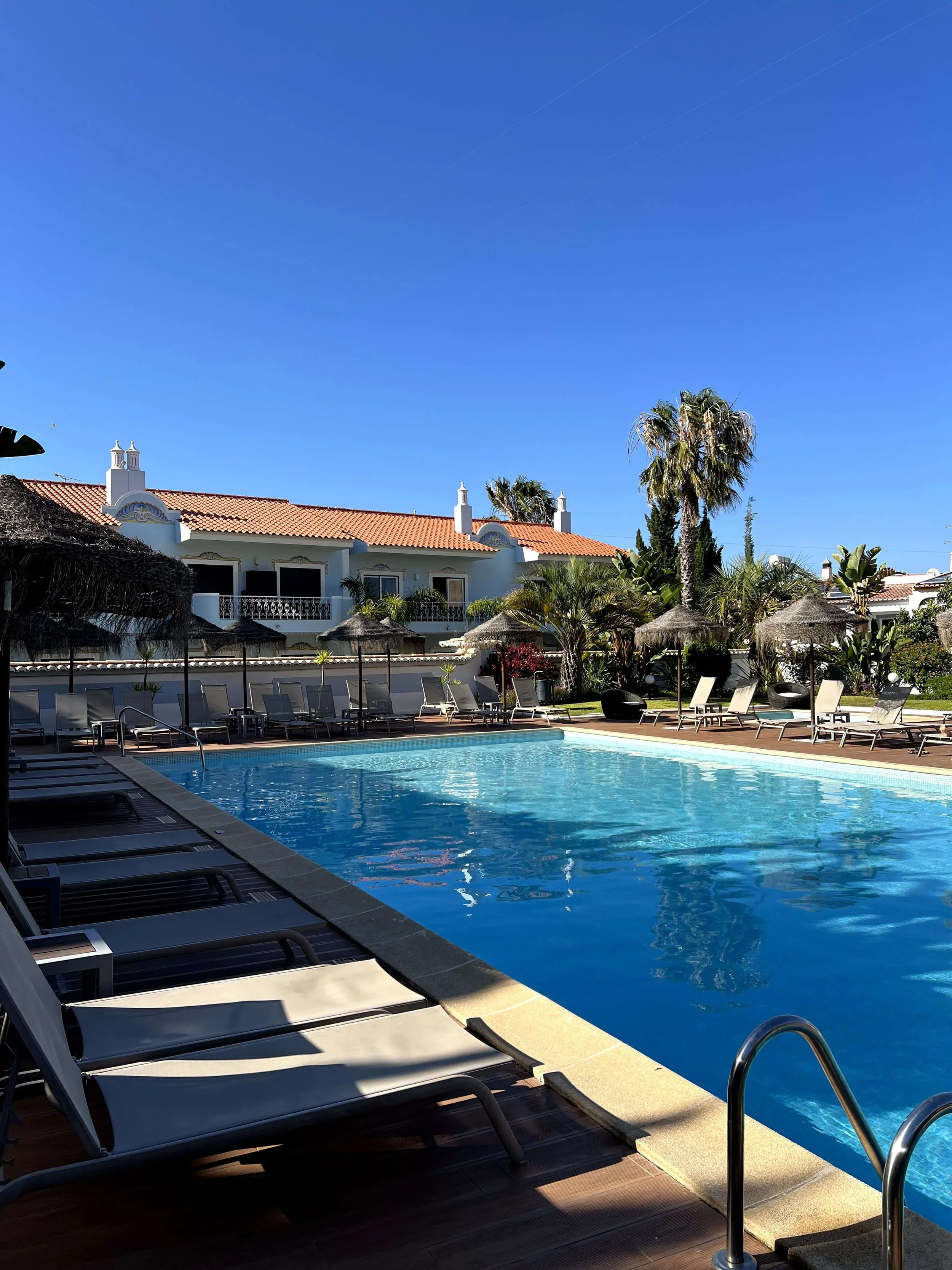 Main pool with sunbeds and traditional Portuguese buildings at Casbah Lagos Algarve