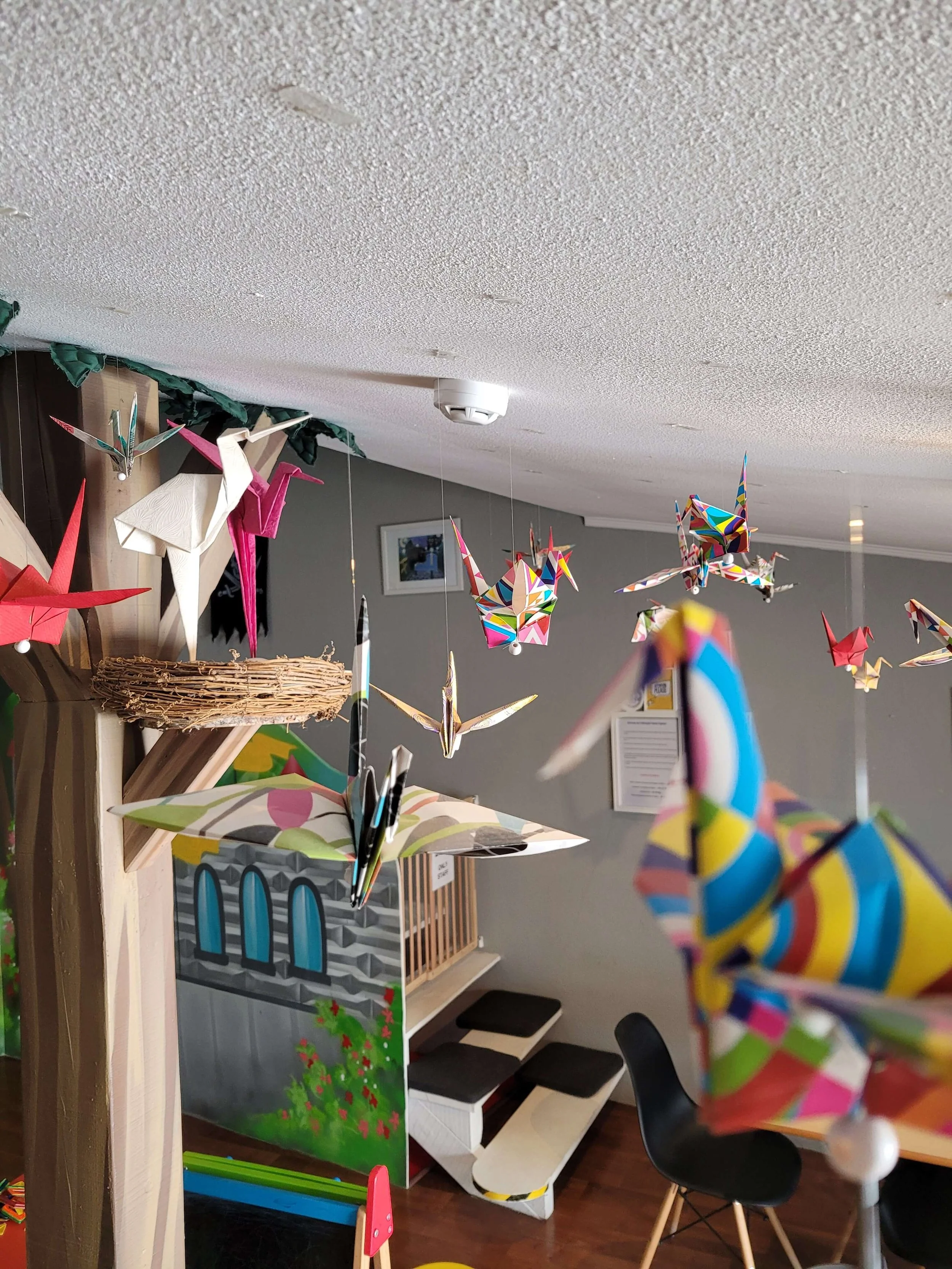 Colourful origami birds hanging from the ceiling at O Ninho family bar Lagos