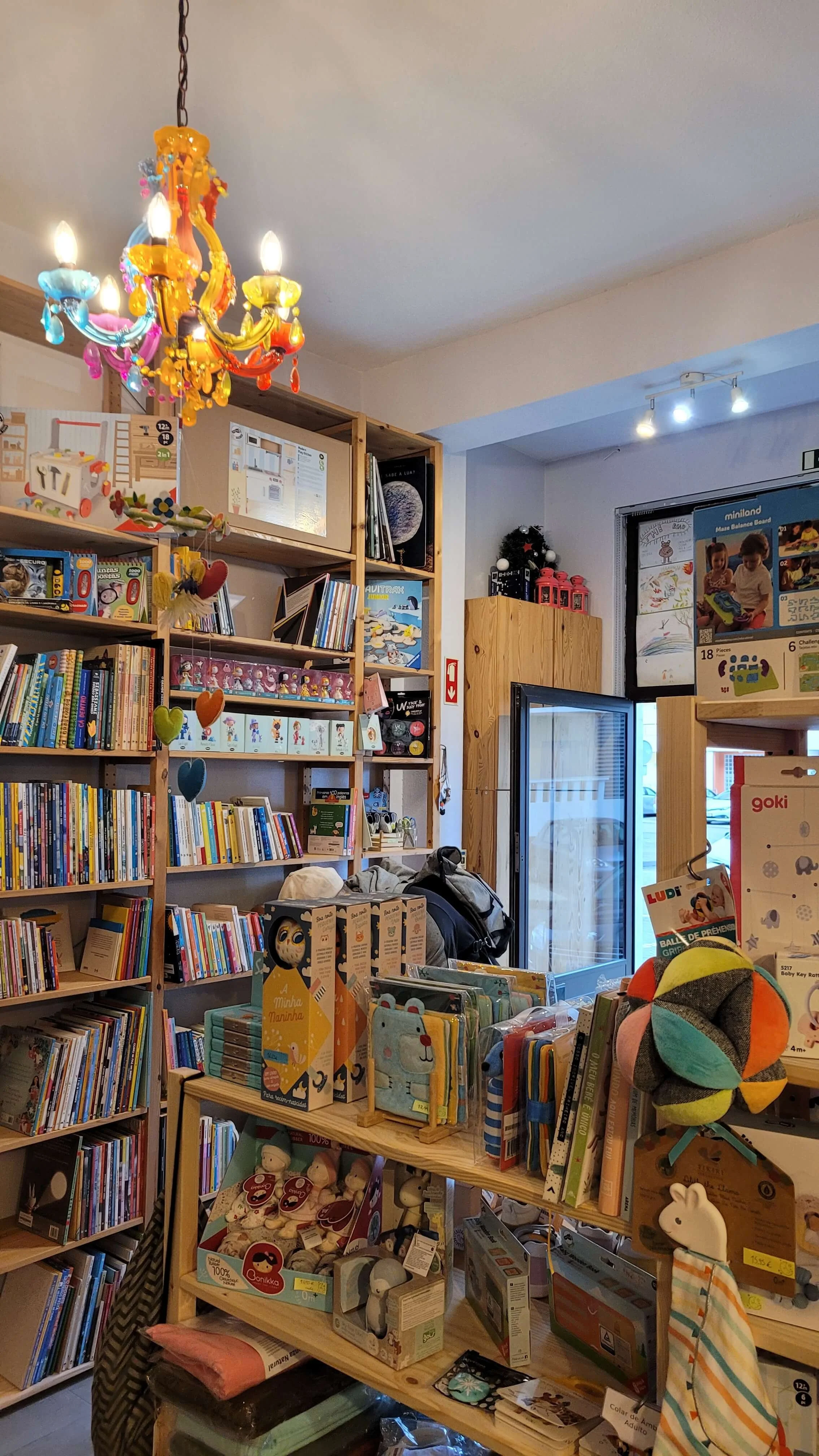 Inside Ate a Lua Lagos with shelves of children's books toys and a colourful chandelier