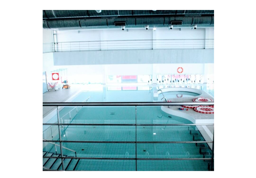 Indoor swimming pool at Piscina Municipal Lagos em Forma with lane markers and toddler pool area