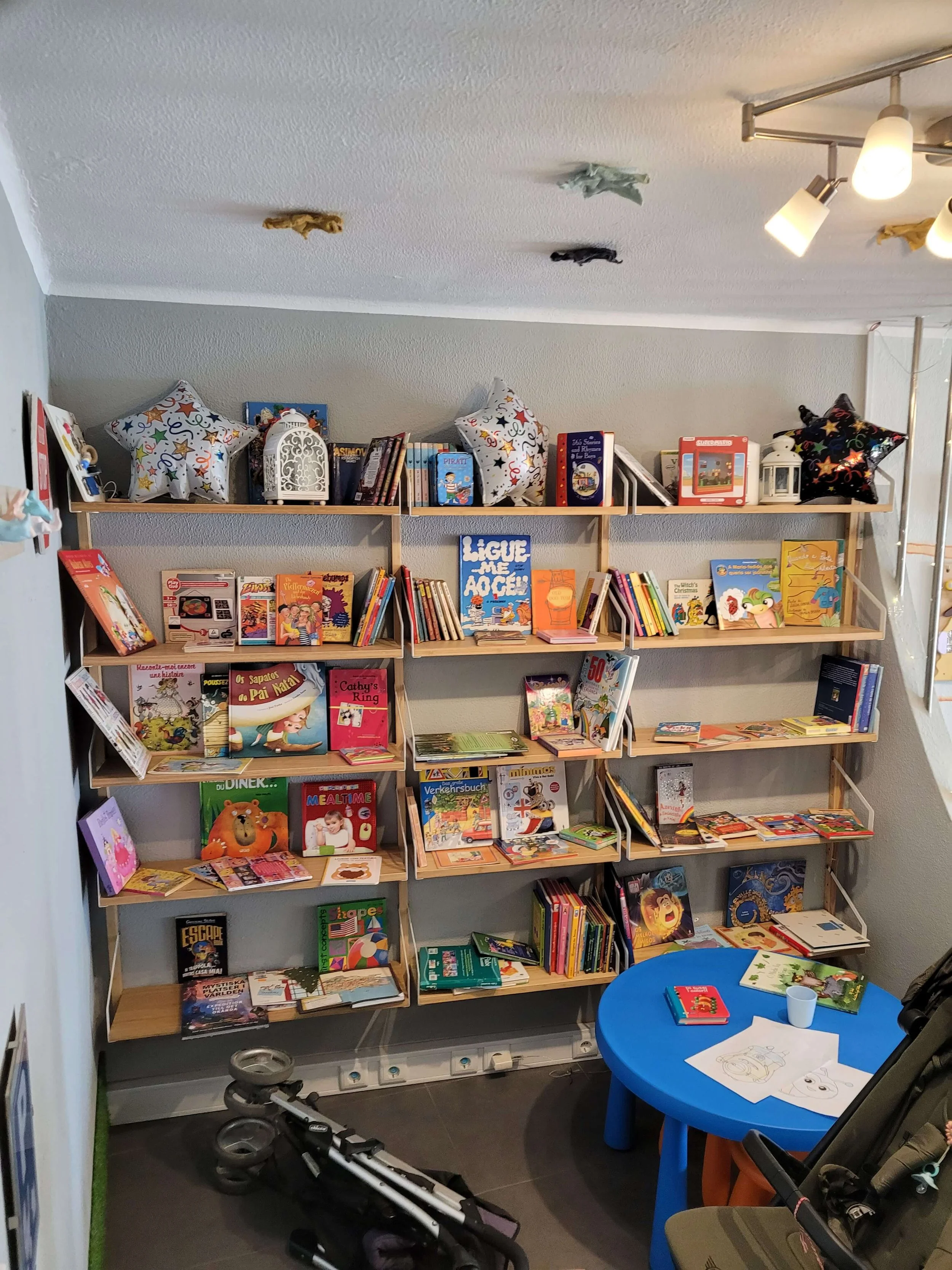 Childrens book shelves with multilingual books and colouring table at O Ninho Lagos