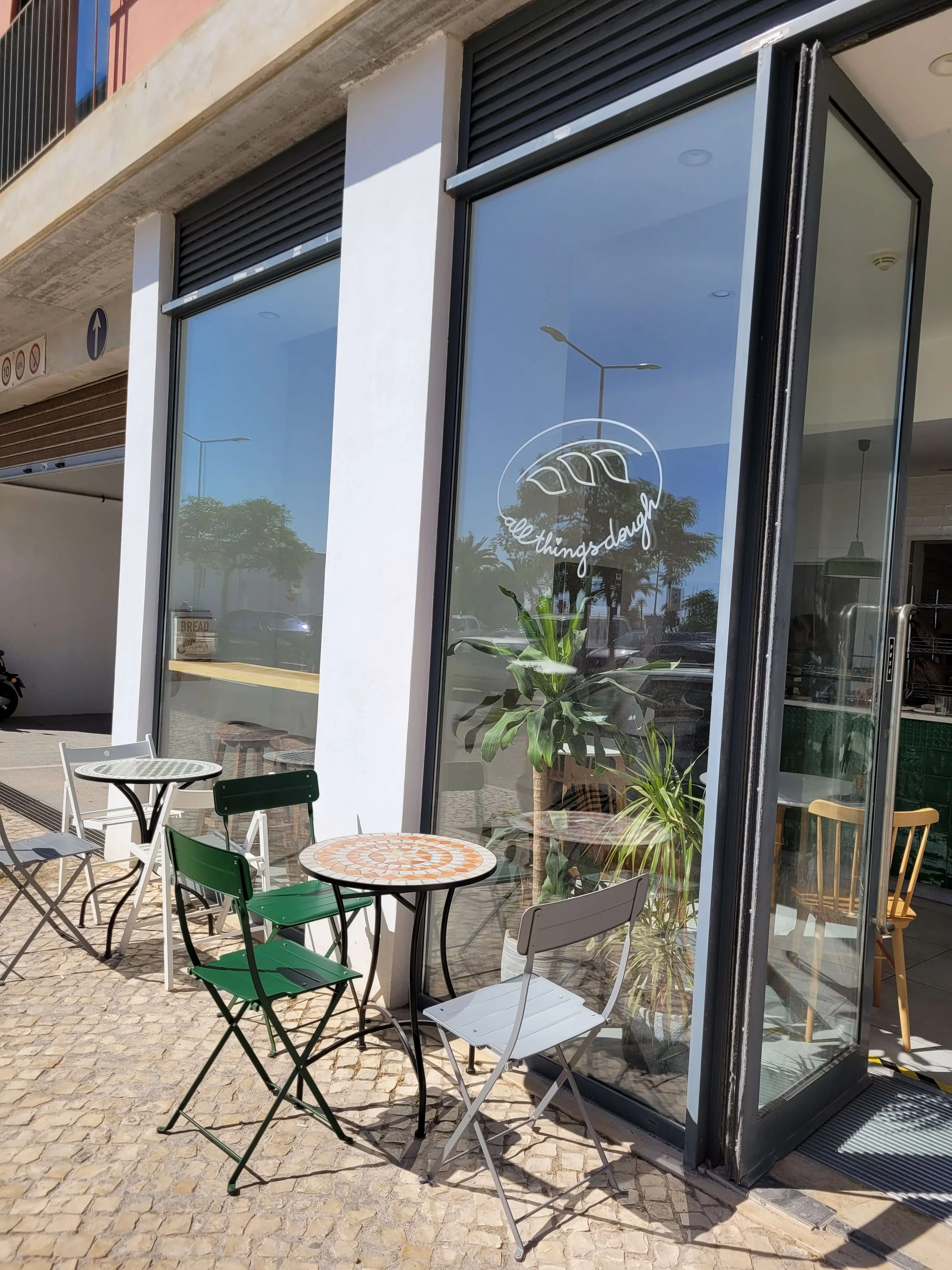 All Things Dough bakery shopfront with outdoor seating on a sunny day in Lagos