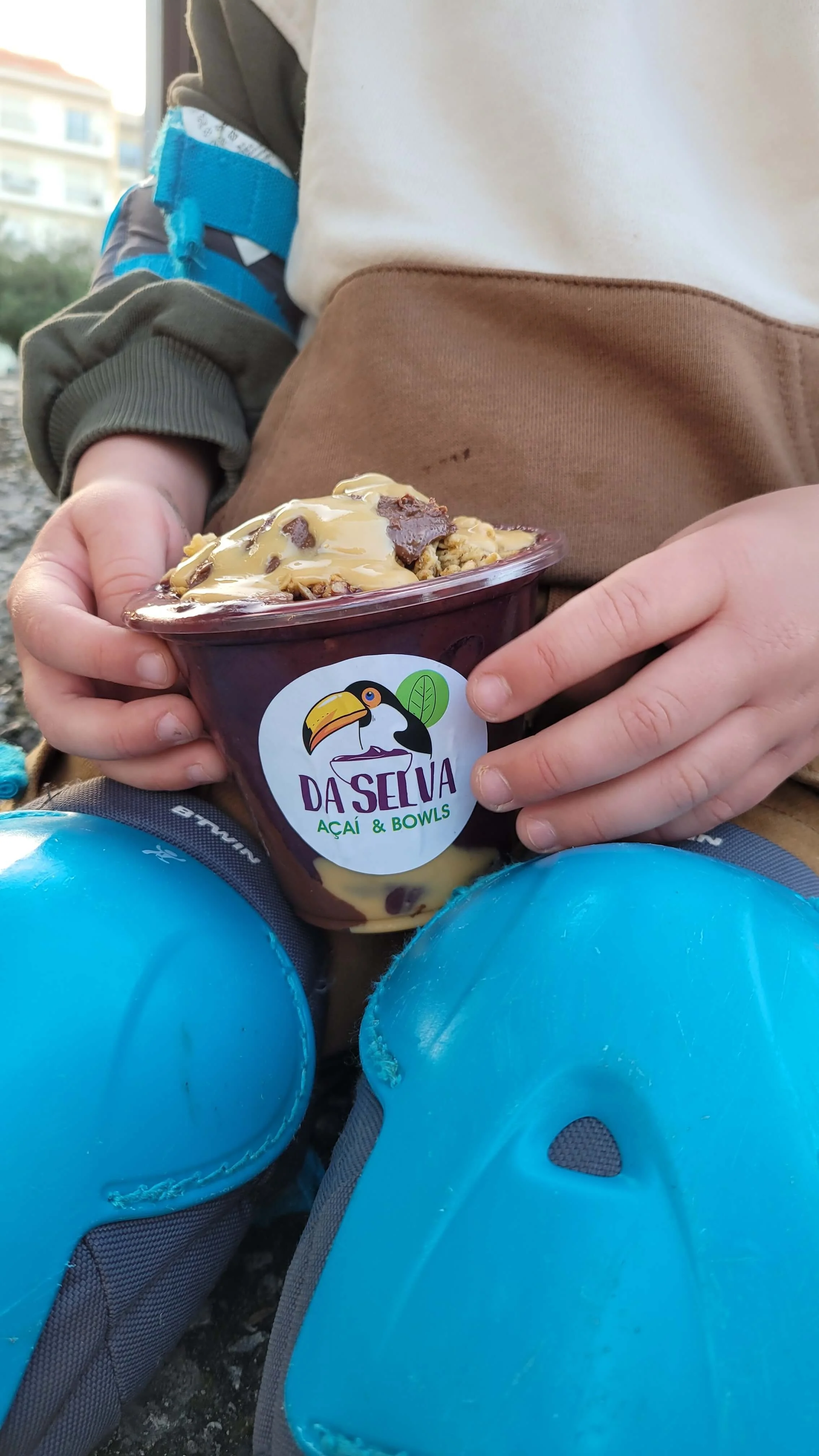 Child holding a Da Selva acai bowl with peanut butter and chocolate toppings in Lagos