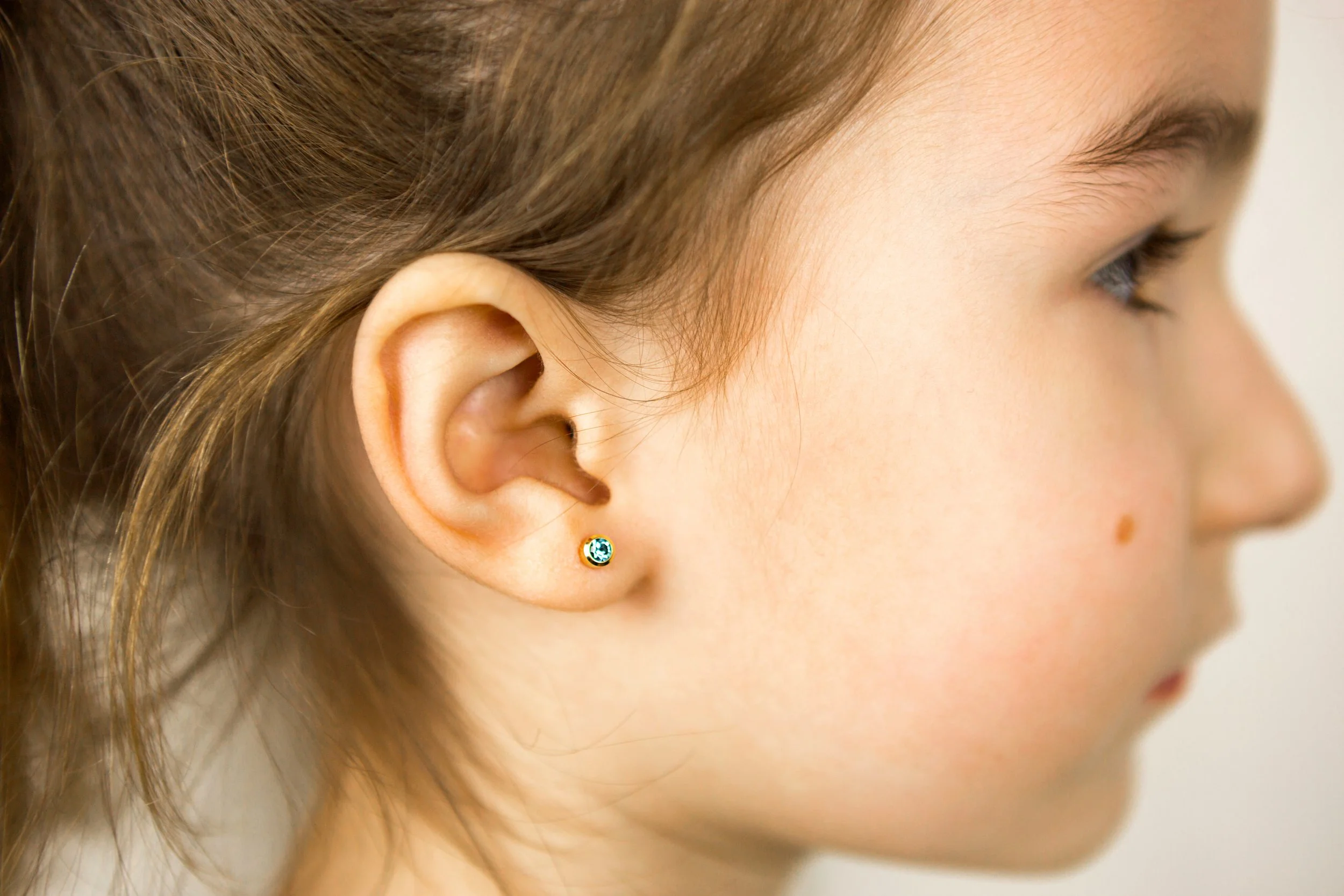 Young girl ear lobe piercing