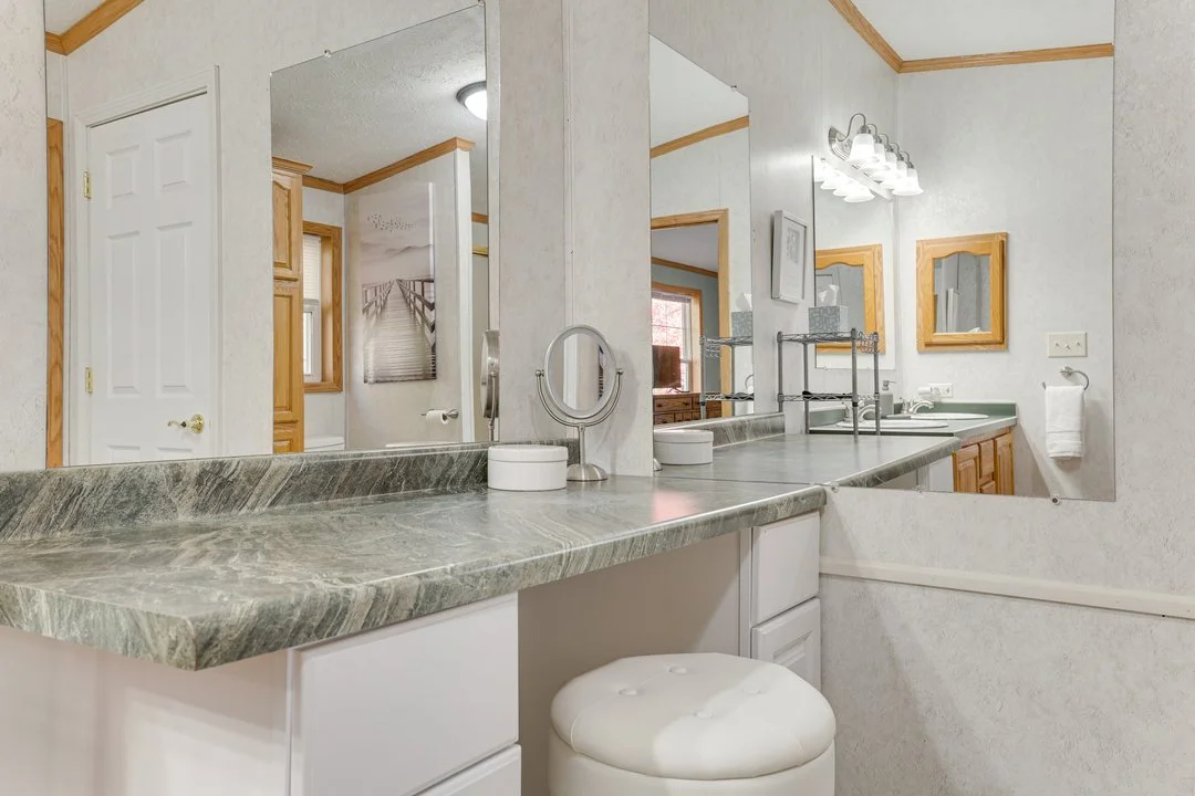 Bathroom vanity with green countertop and round white stool