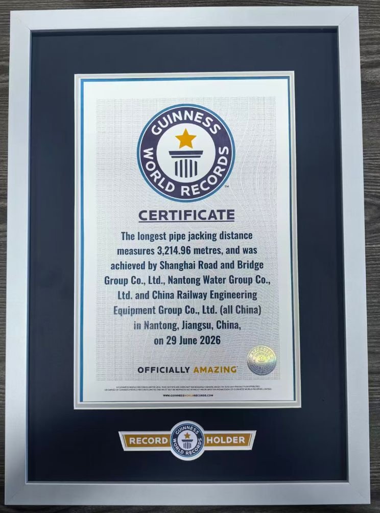 Guinness World Records certificate for the longest pipe jacking distance measuring 3,214.96 meters, achieved by multiple groups in Nantong, Jiangsu, China, on June 29, 2026, framed and placed on a wooden surface. Jello Mud was used on this Project