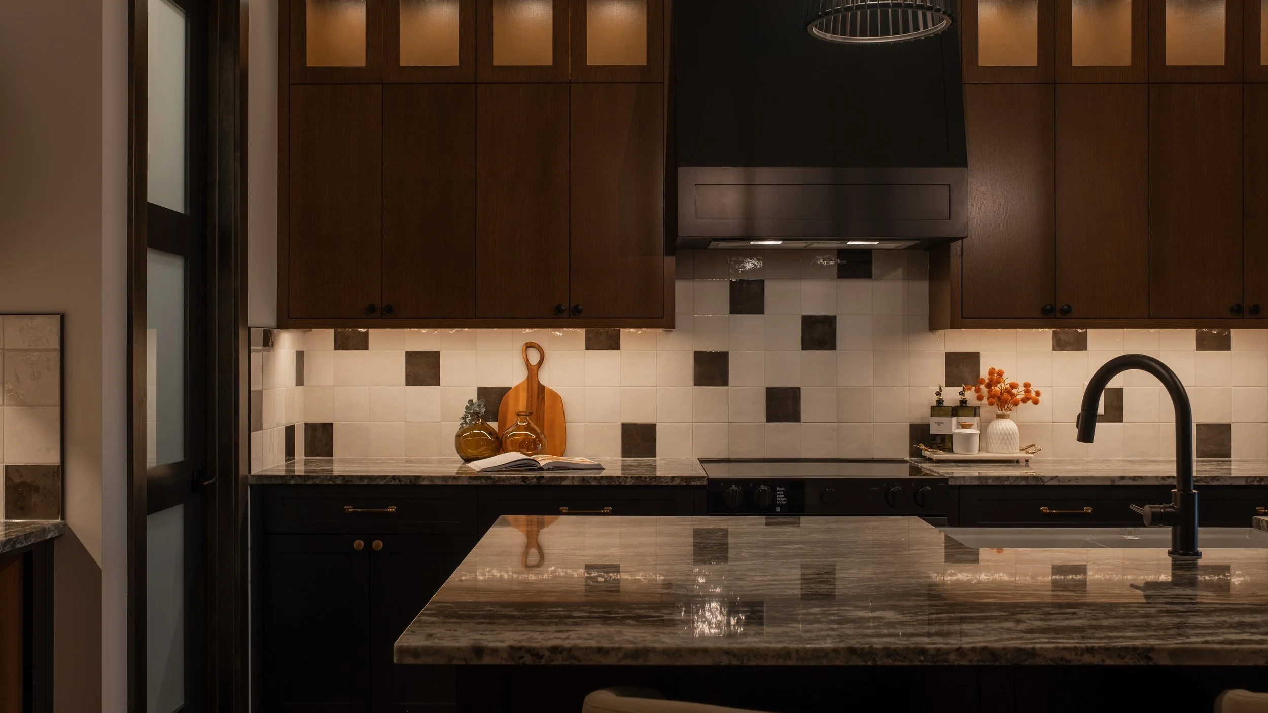 Image of a new kitchen with cabinets and under-lit back splash