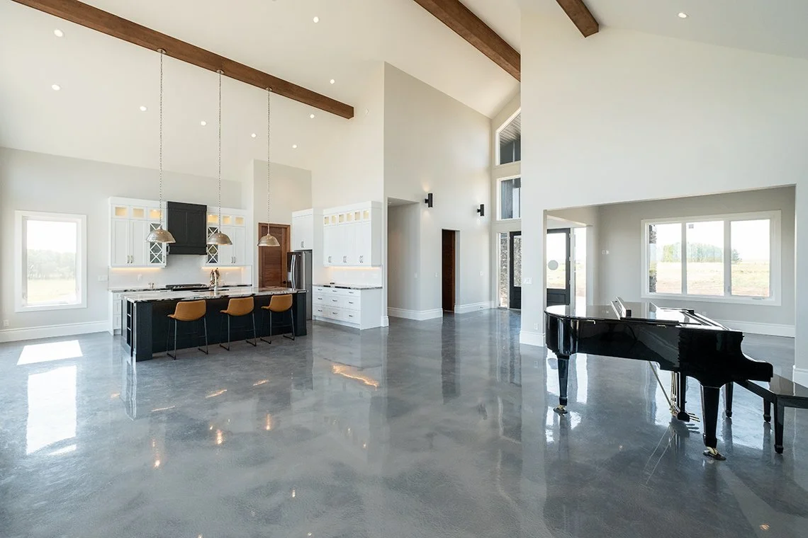 Image of modern home interior, with polished concrete floor, vaulted ceiling and open plan kitchen