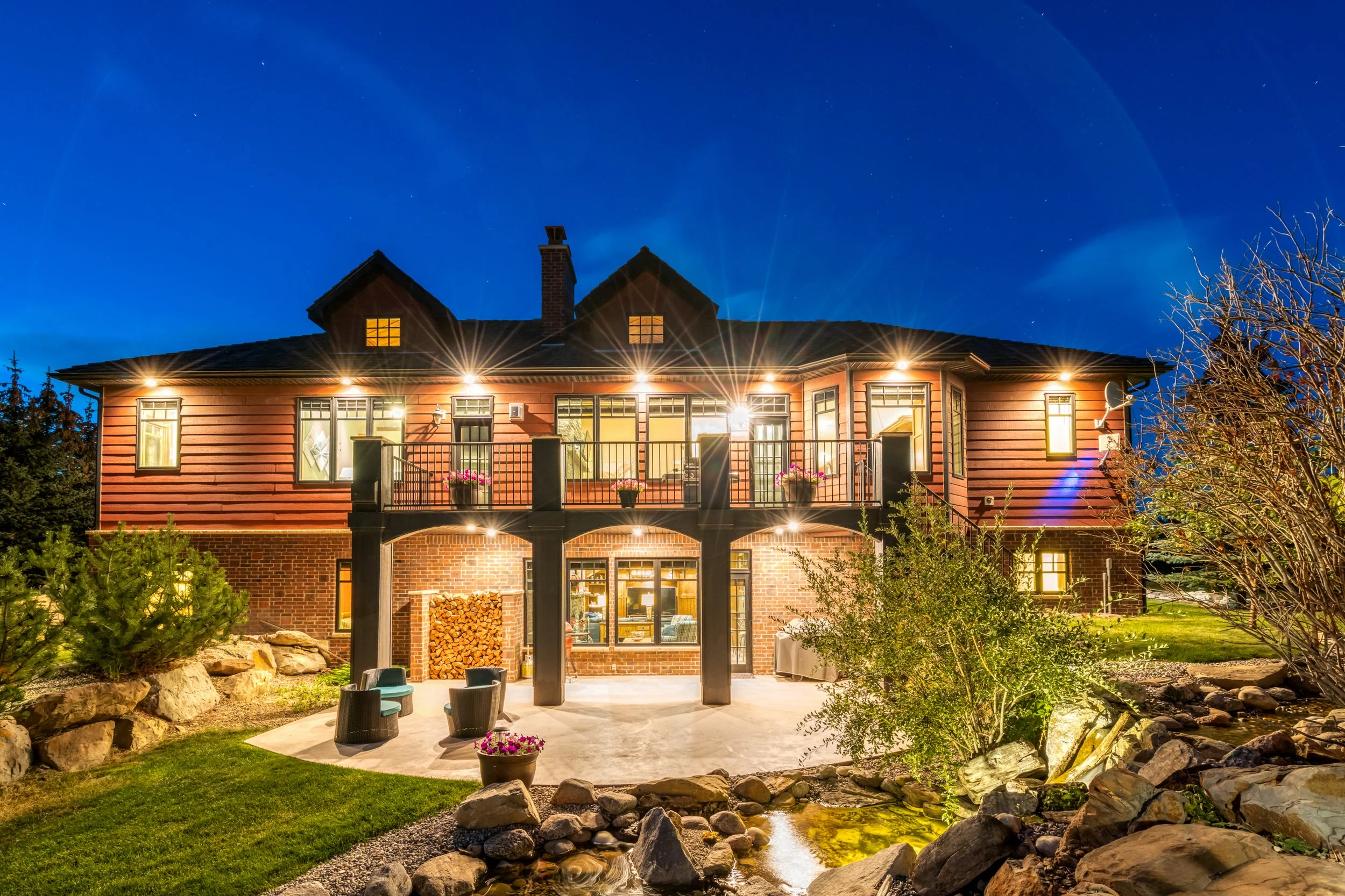 Image of modern home exterior at dusk with all the lights of the house on