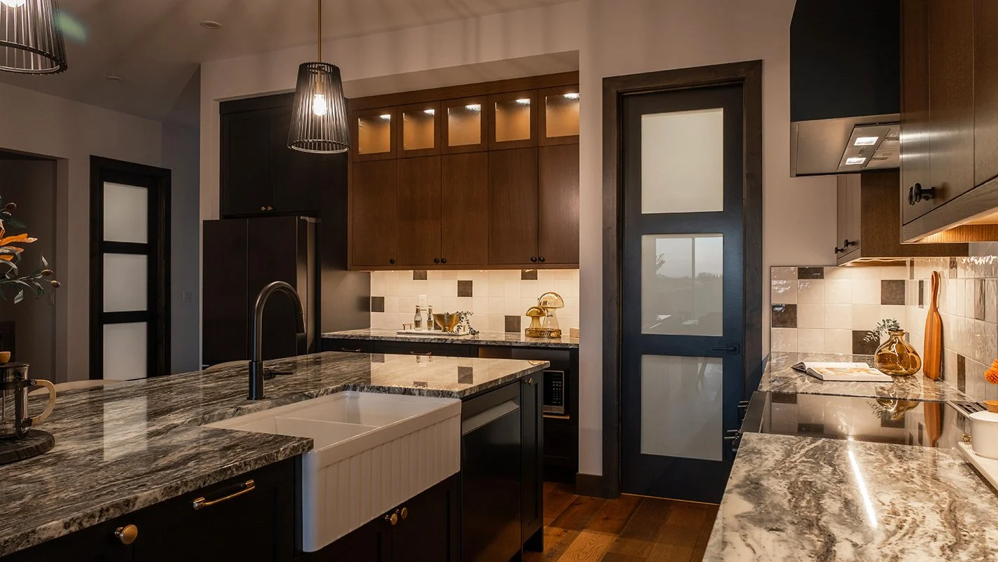 Image of kitchen with marble countertops and dark wood cabinets