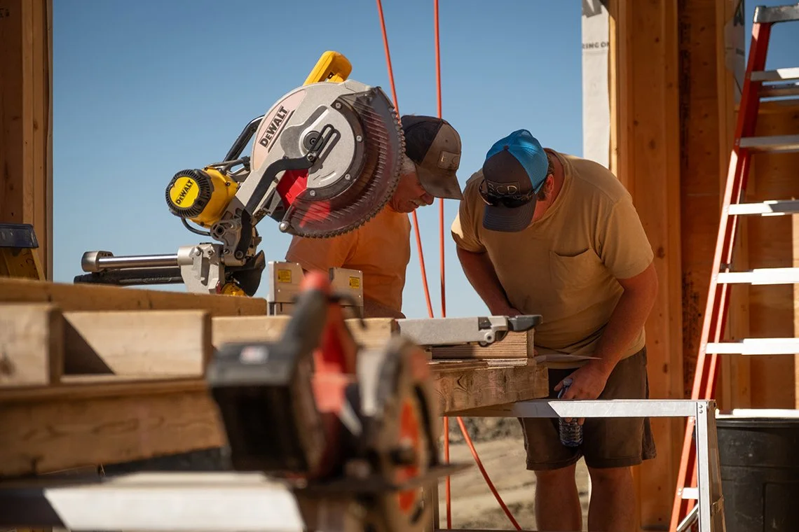 Image of contractors cutting lumbar with a sliding chop saw
