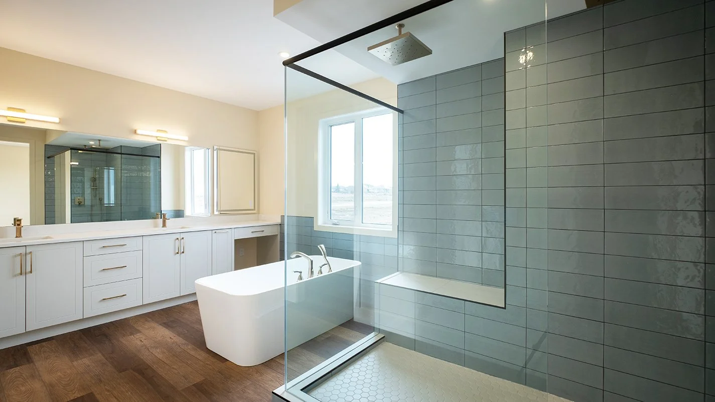Image of modern bathroom with glass shower, free standing tub and dual sinks