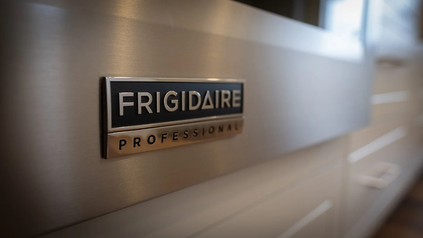 Close up image of the "Frigidaire" logo on a stainless steel microwave
