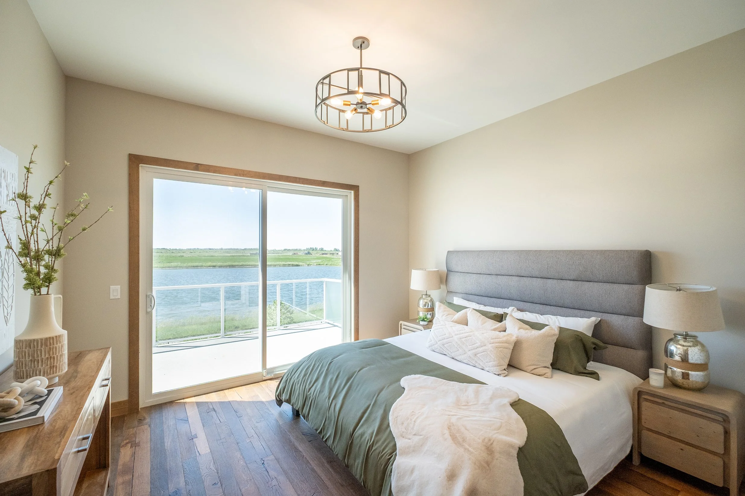 Image of bright bedroom, with view of lake through the patio windows