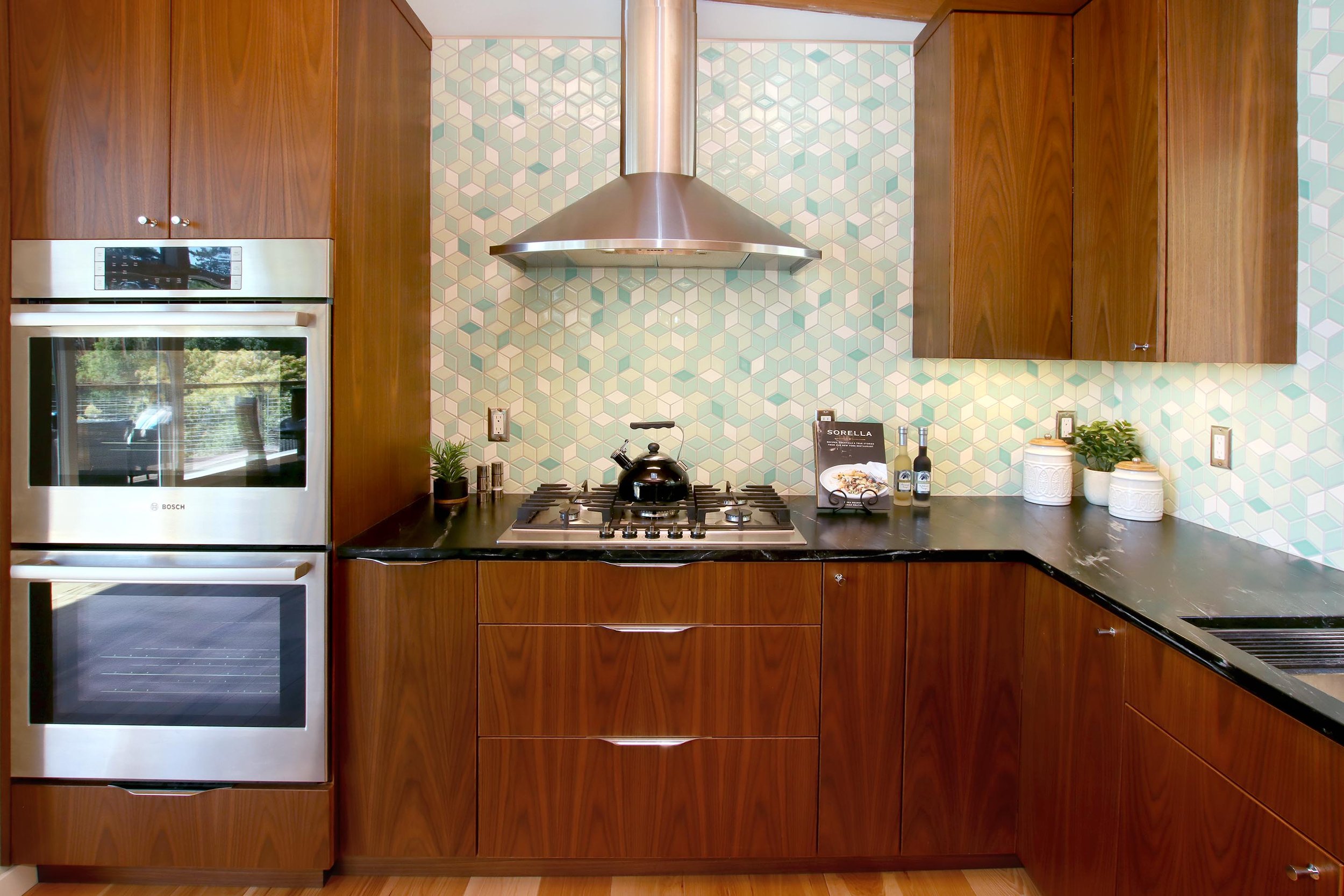 Unique full-height, green geometric tile backsplash design.