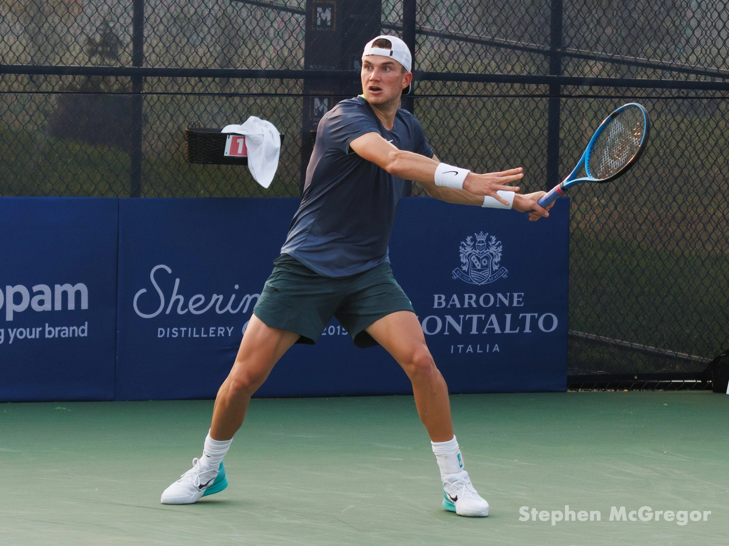 Jack Draper winds up to hit a tennis ball with his racket in a tennis match.