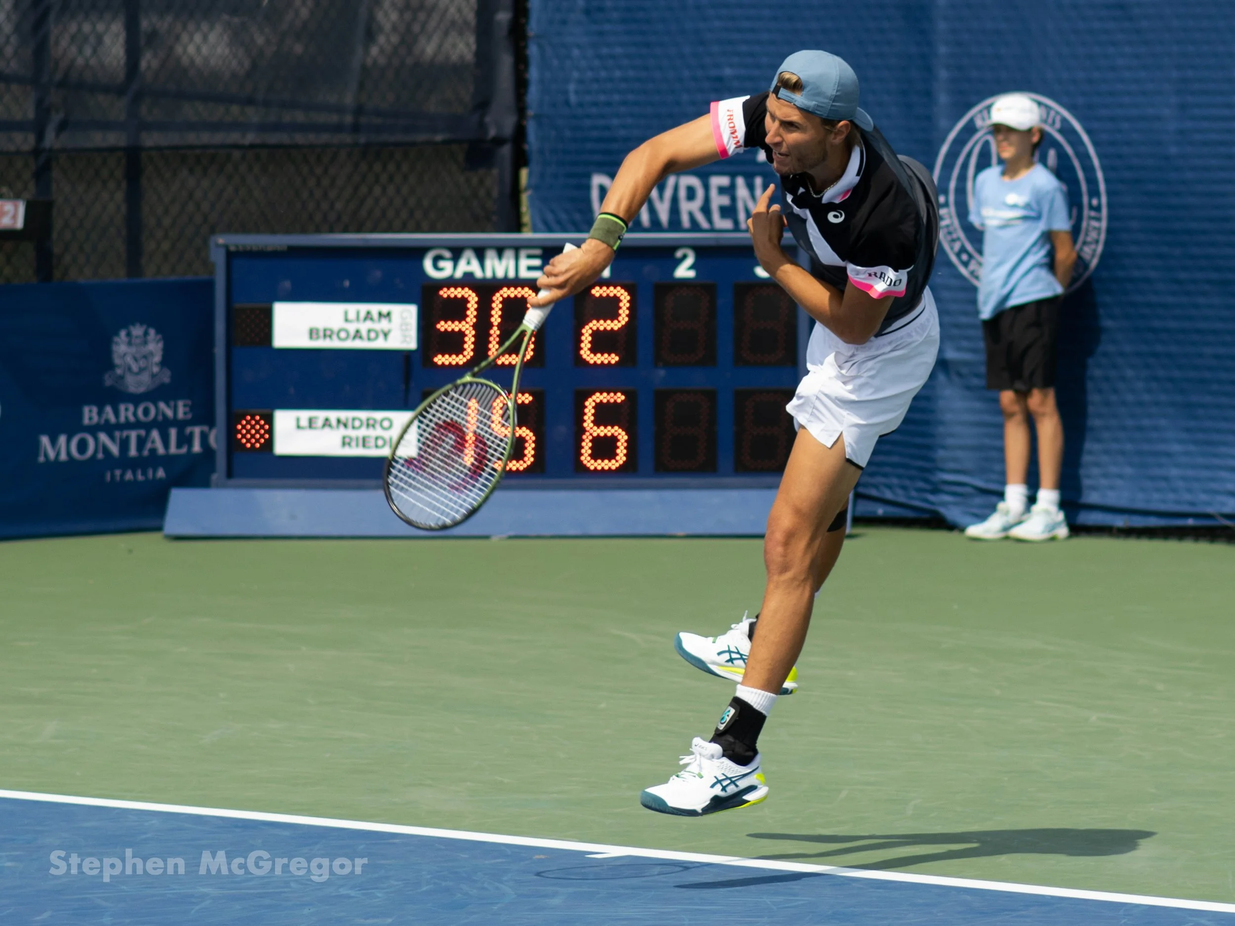 Leandro Riedi follows through on his serve in a tennis match.