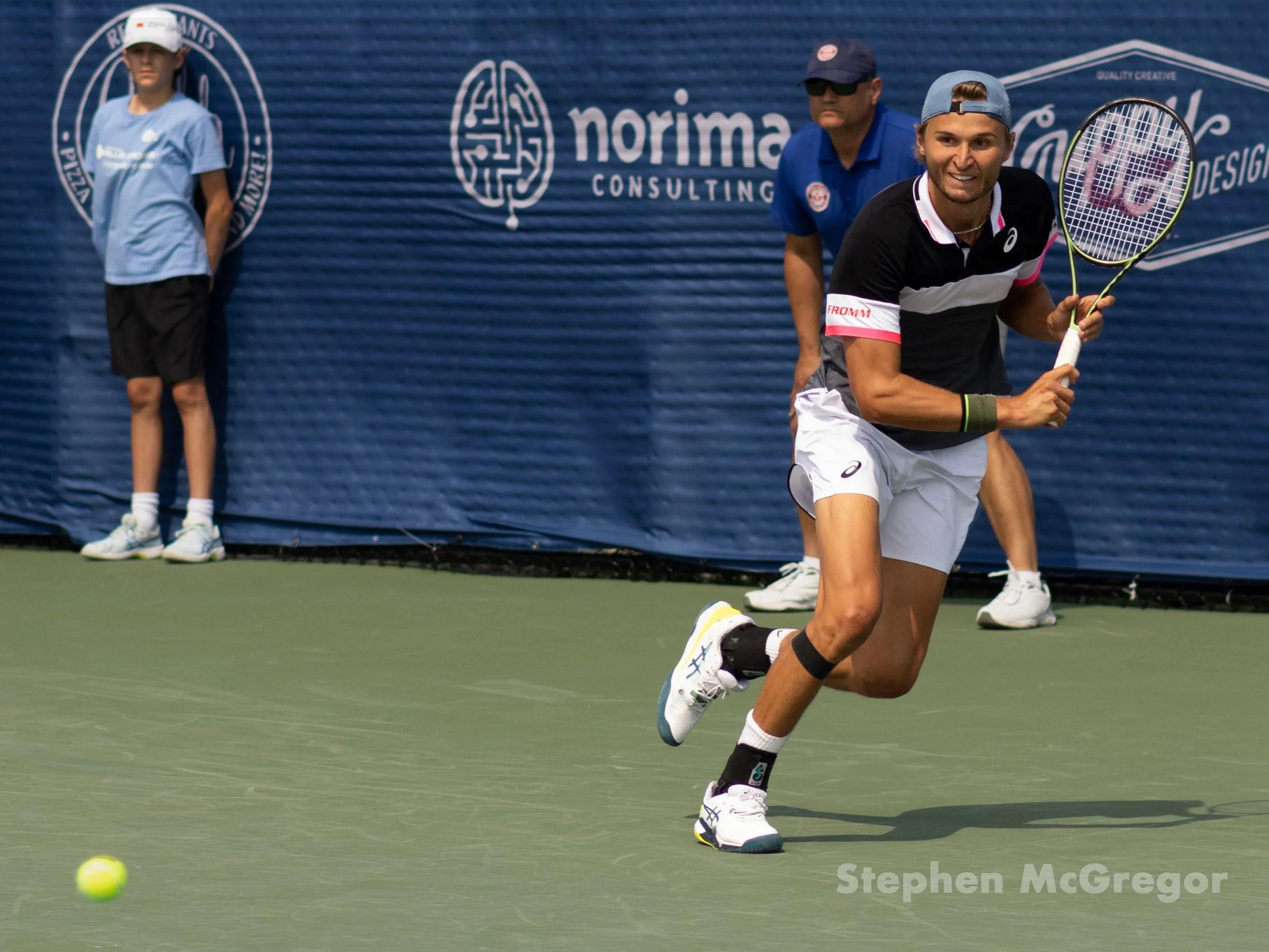 Leandro Riedi runs across the court to hit a tennis ball in a tennis match.
