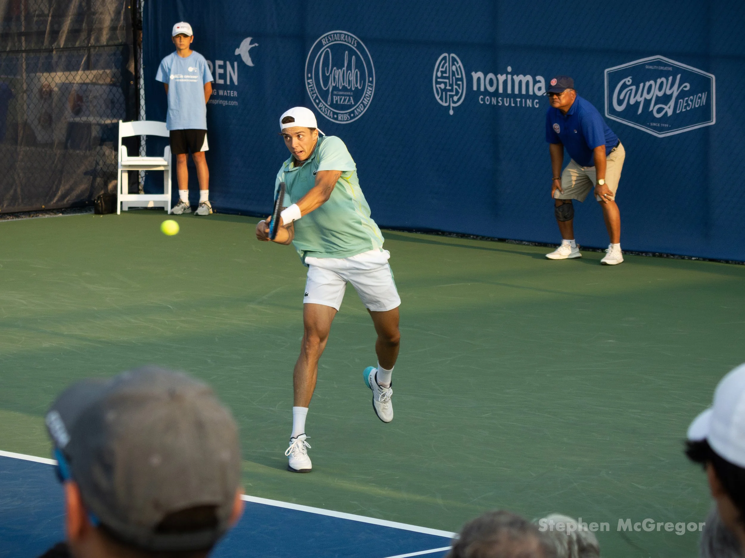 Arthur Cazaux hits the tennis ball with a backhand stroke in a tennis match