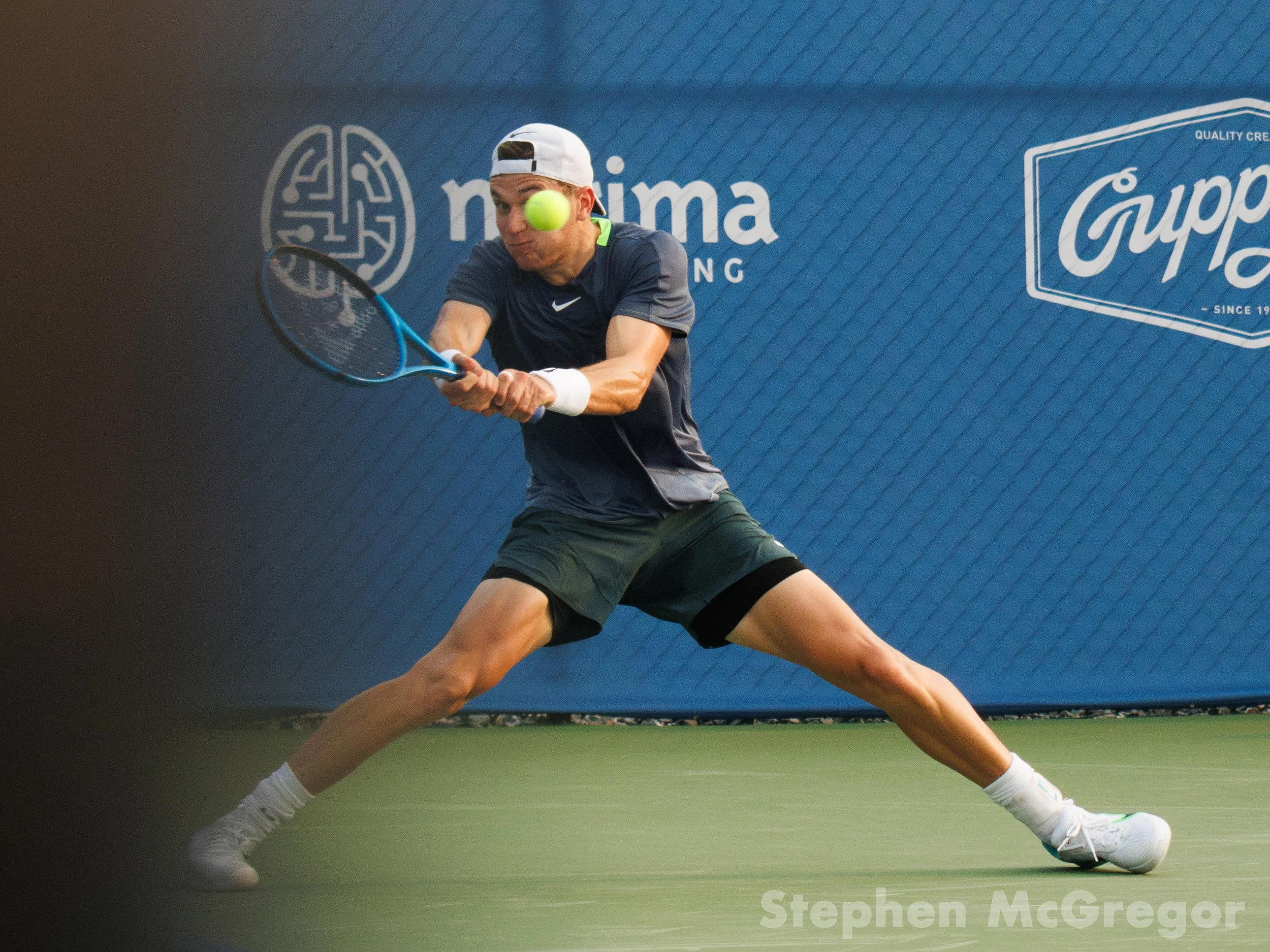 Jack Draper lunges to hit the tennis ball in a tennis match.
