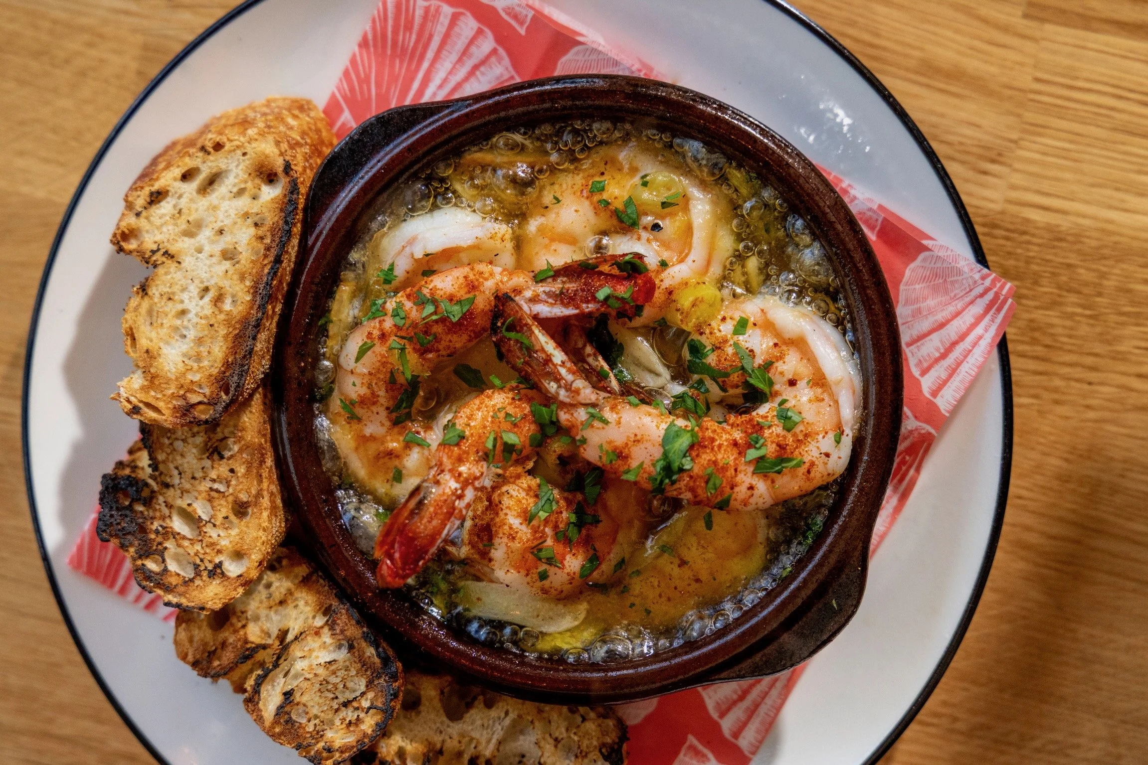 Gambas al ajillo served with grilled bread at XUNTOS