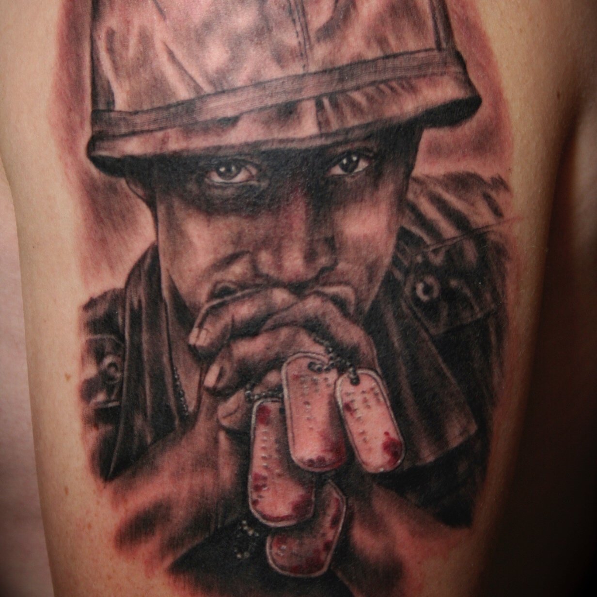 Black and grey portrait of a veteran praying with dog tags done by Daniel Stewart at Signature Rose Professional Tattooing in Muncie Indiana.