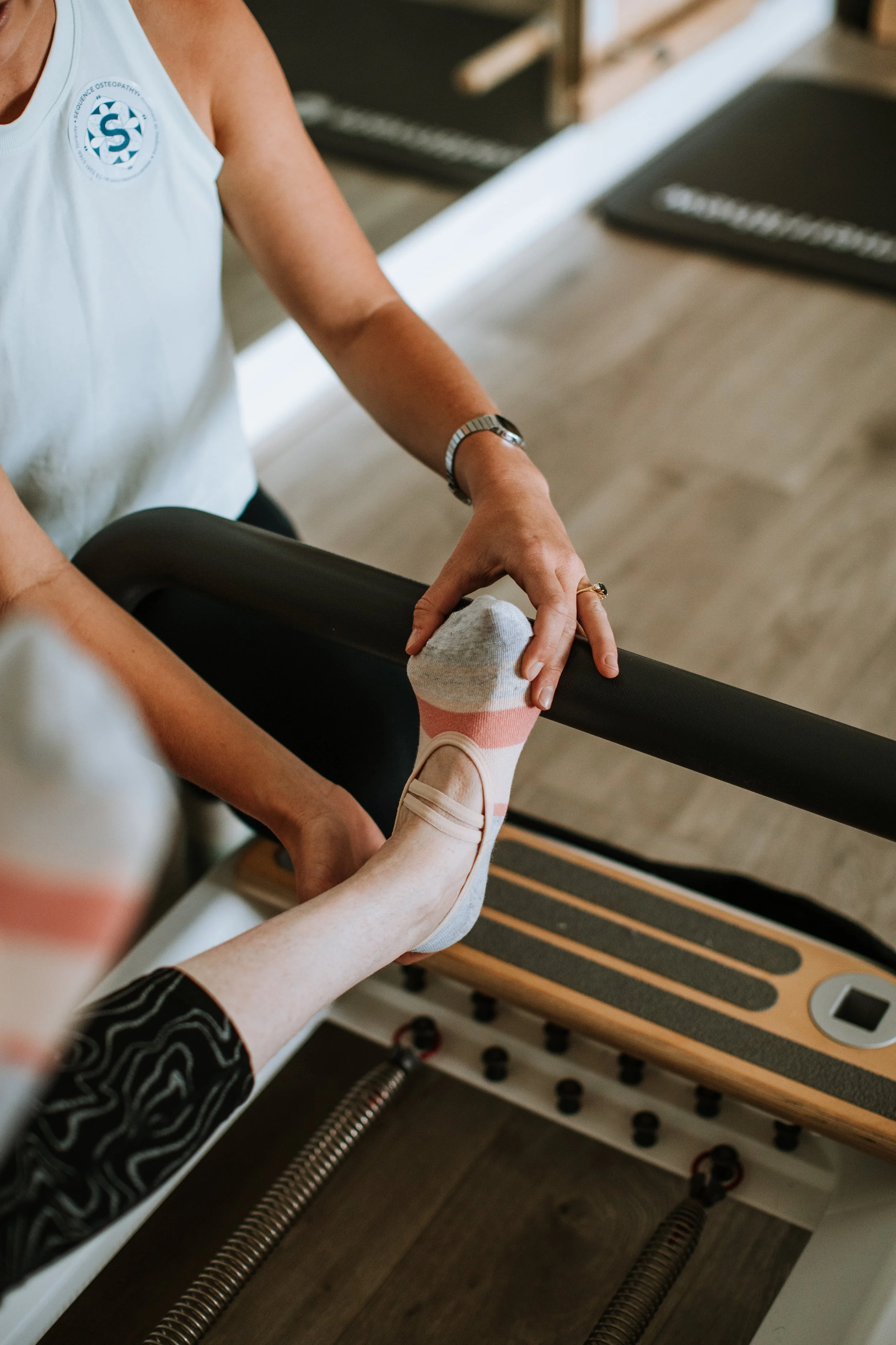 Group on Women sitting on pilates mats. One is in a lunge, another in a mermaid pose and other cross legged.