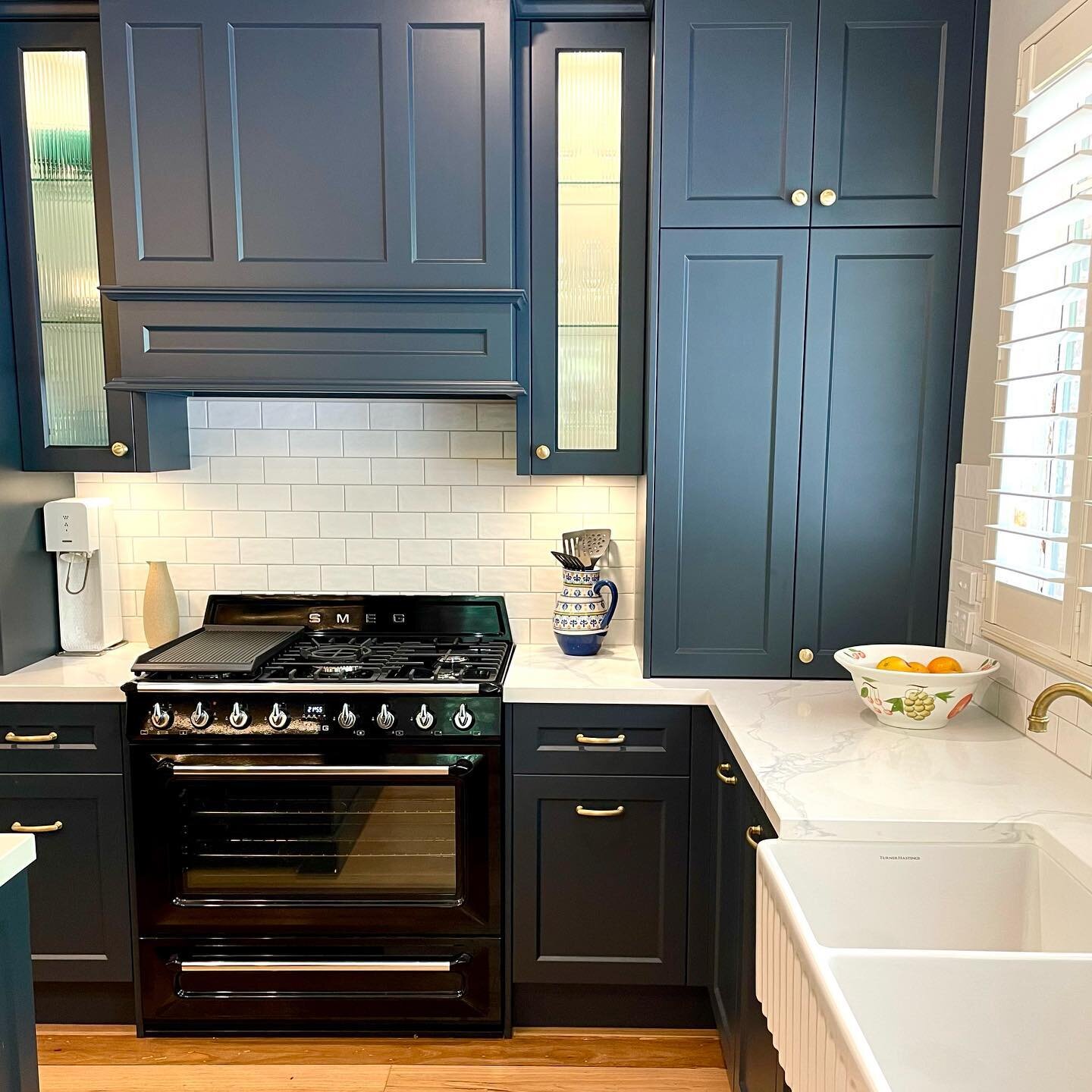 Designing this navy blue traditional kitchen was an absolute pleasure! It was so rewarding to see it all come together with the stunning black Smeg cooker, statement Turner Hastings fireclay sink, and elegant engineered stone bench top. The feature f