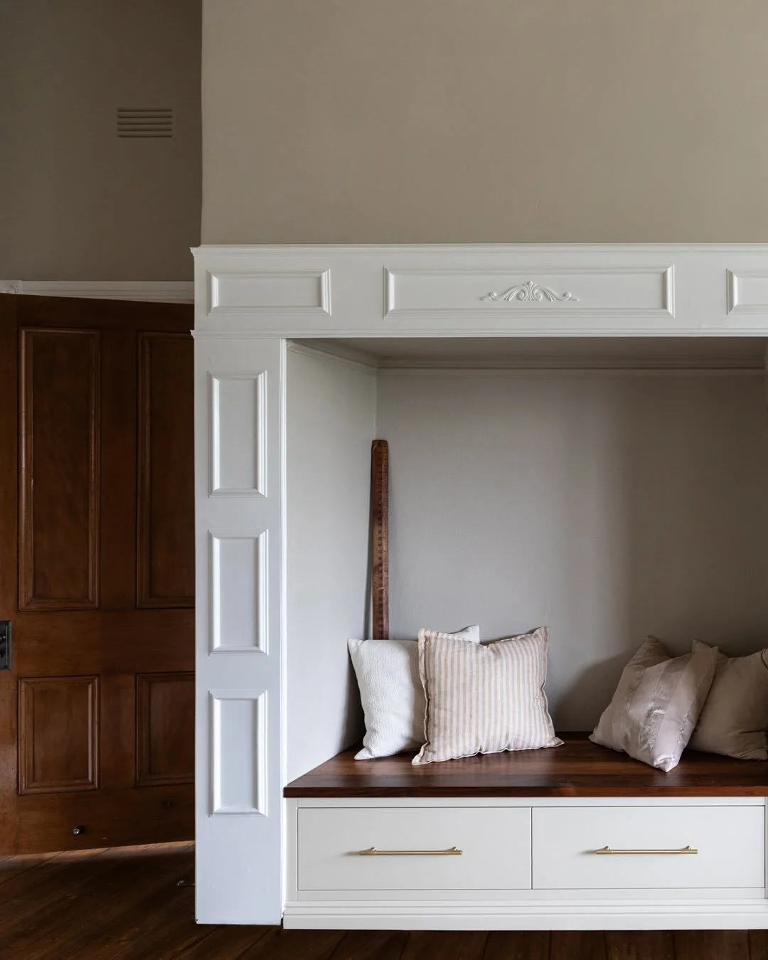 Older homes often come with charming features that no longer serve their original purpose, like this large, unused fireplace in the entry hall. We reimagined it as a practical and welcoming seat, the perfect spot to put your shoes on as you come and 